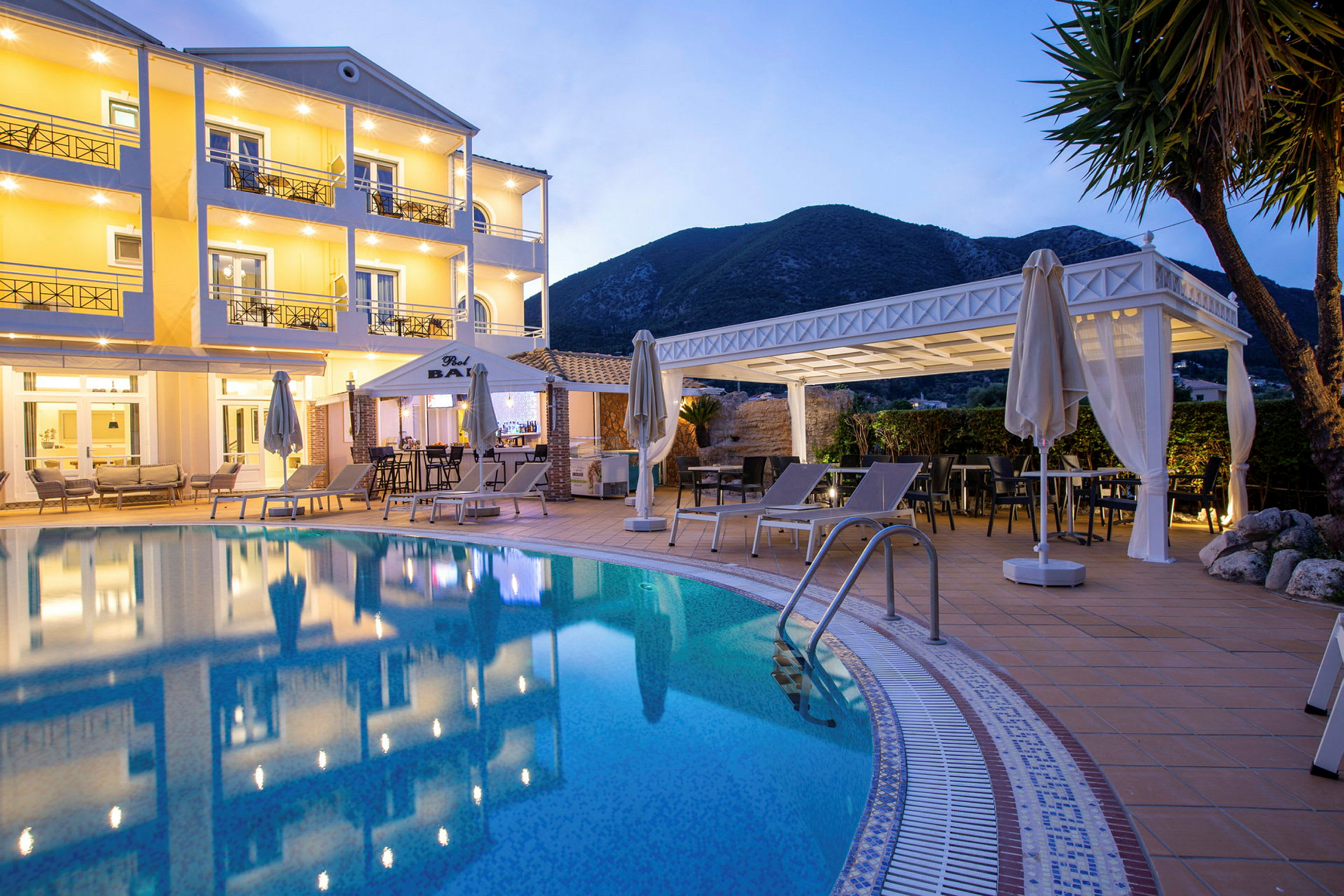 Hotellfasad med pool och solstolar i förgrunden. (AI-genererad text)