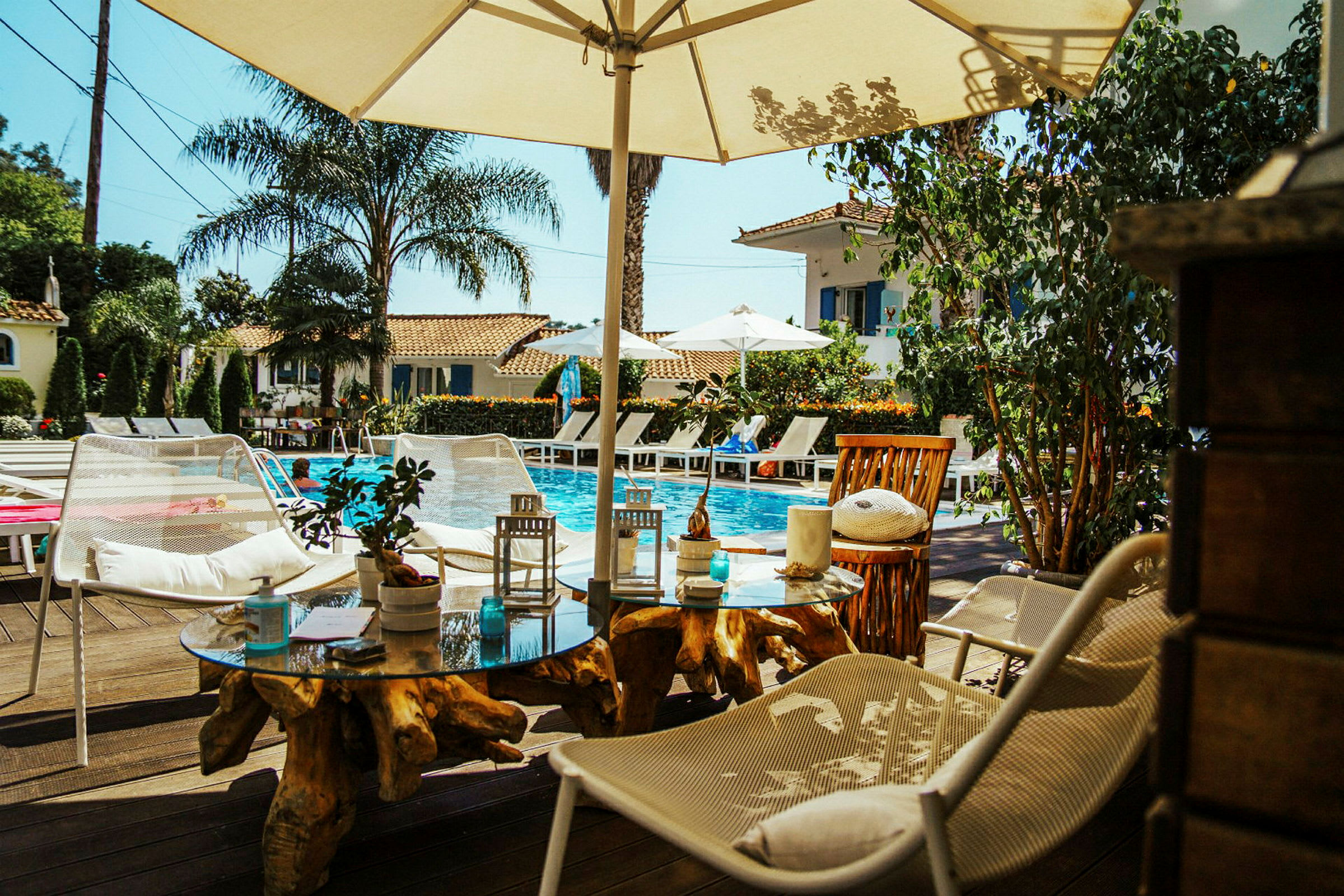 En pool med solsängar och parasoller i ett soligt hotellområde. (AI-genererad text)