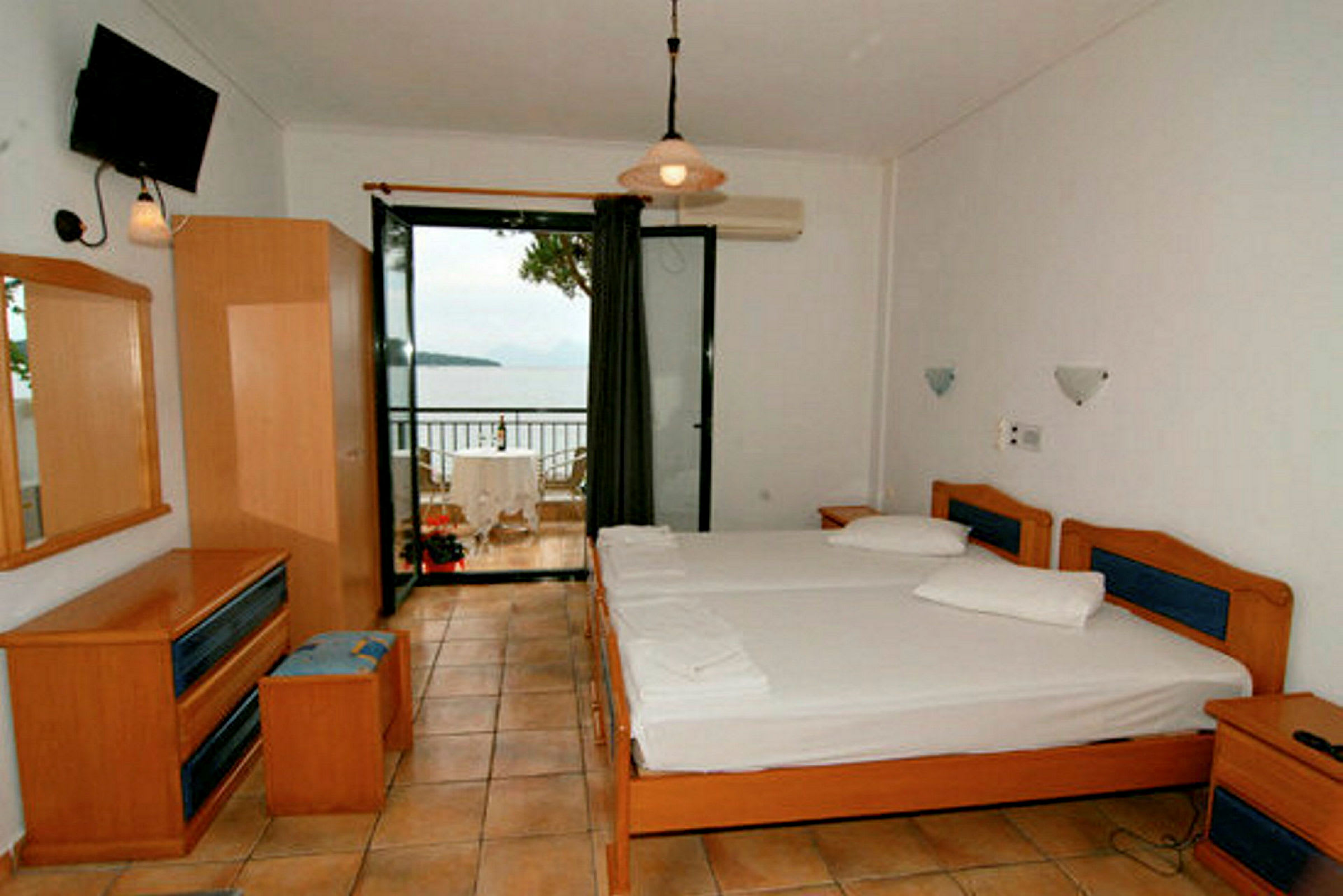 Ett hotellrum med två enkelsängar och en balkong med utsikt över havet. (AI-genererad text)