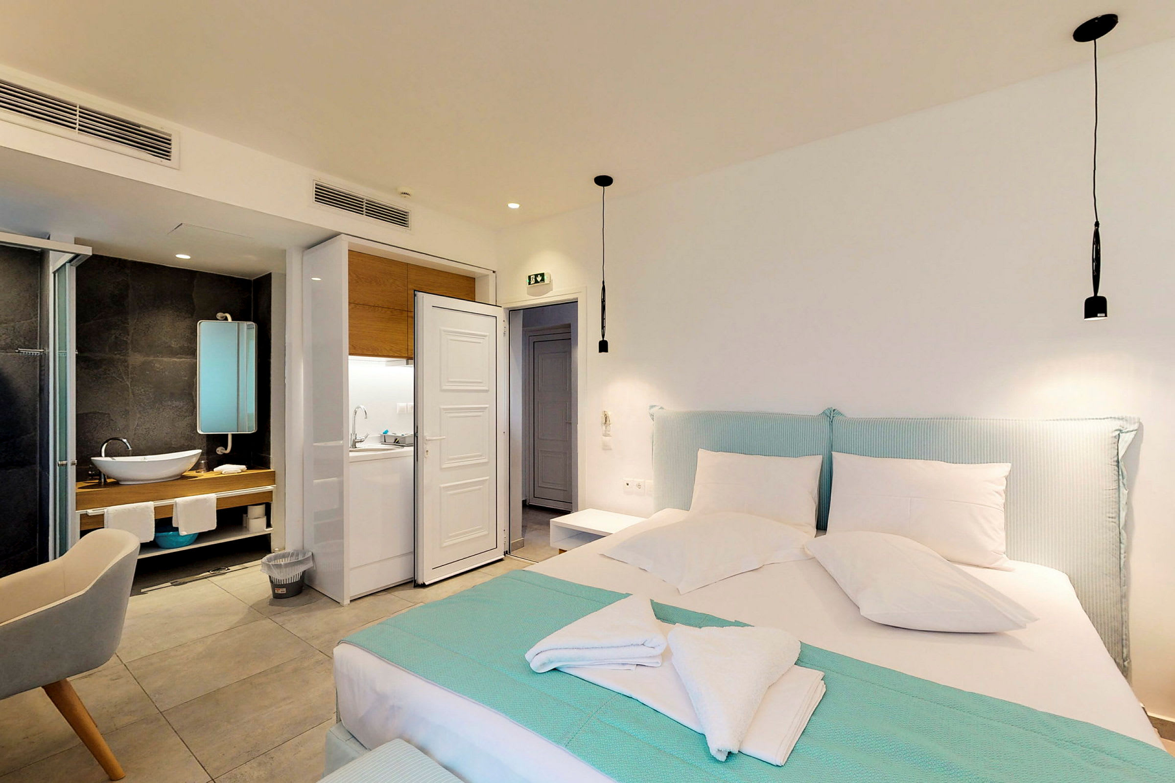 Ett modernt hotellrum med en säng, sittmöbel och badrum. (AI-genererad text)