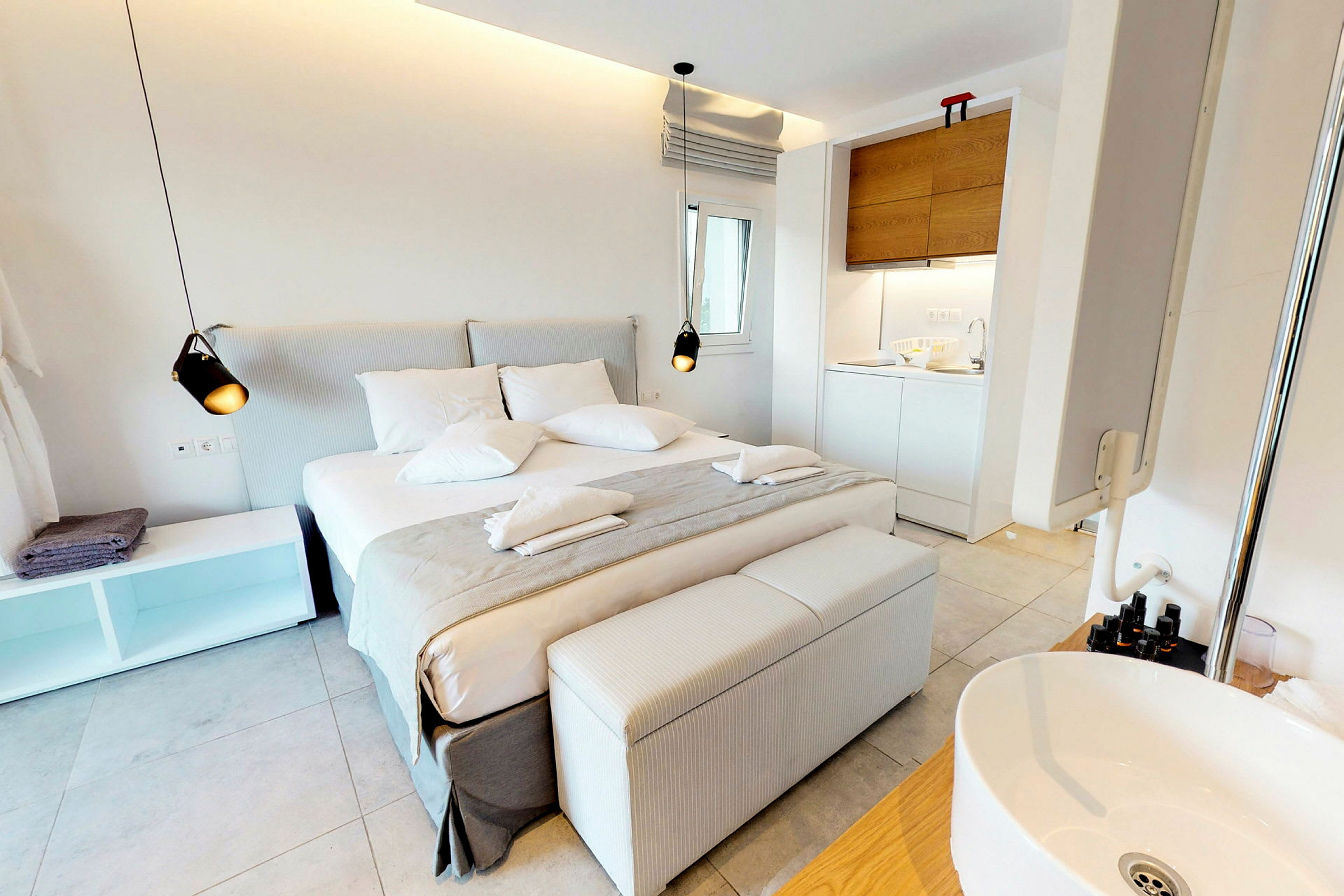 Ett ljust hotellrum med säng, soffa och pentry. (AI-genererad text)
