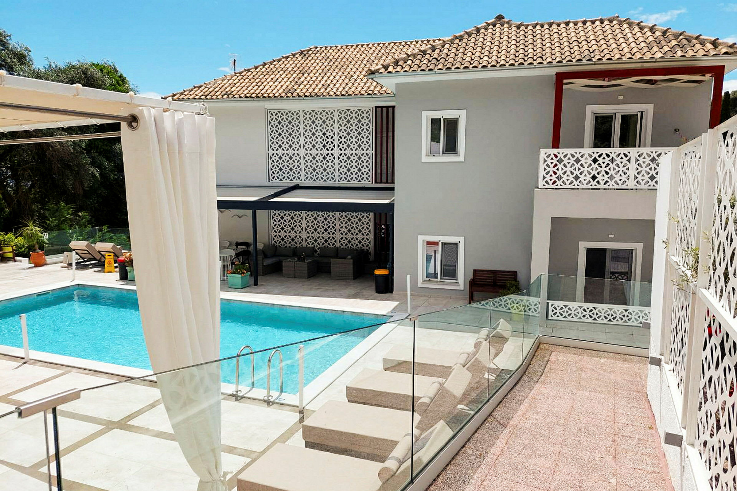 En modern villa med swimmingpool och solstolar. (AI-genererad text)