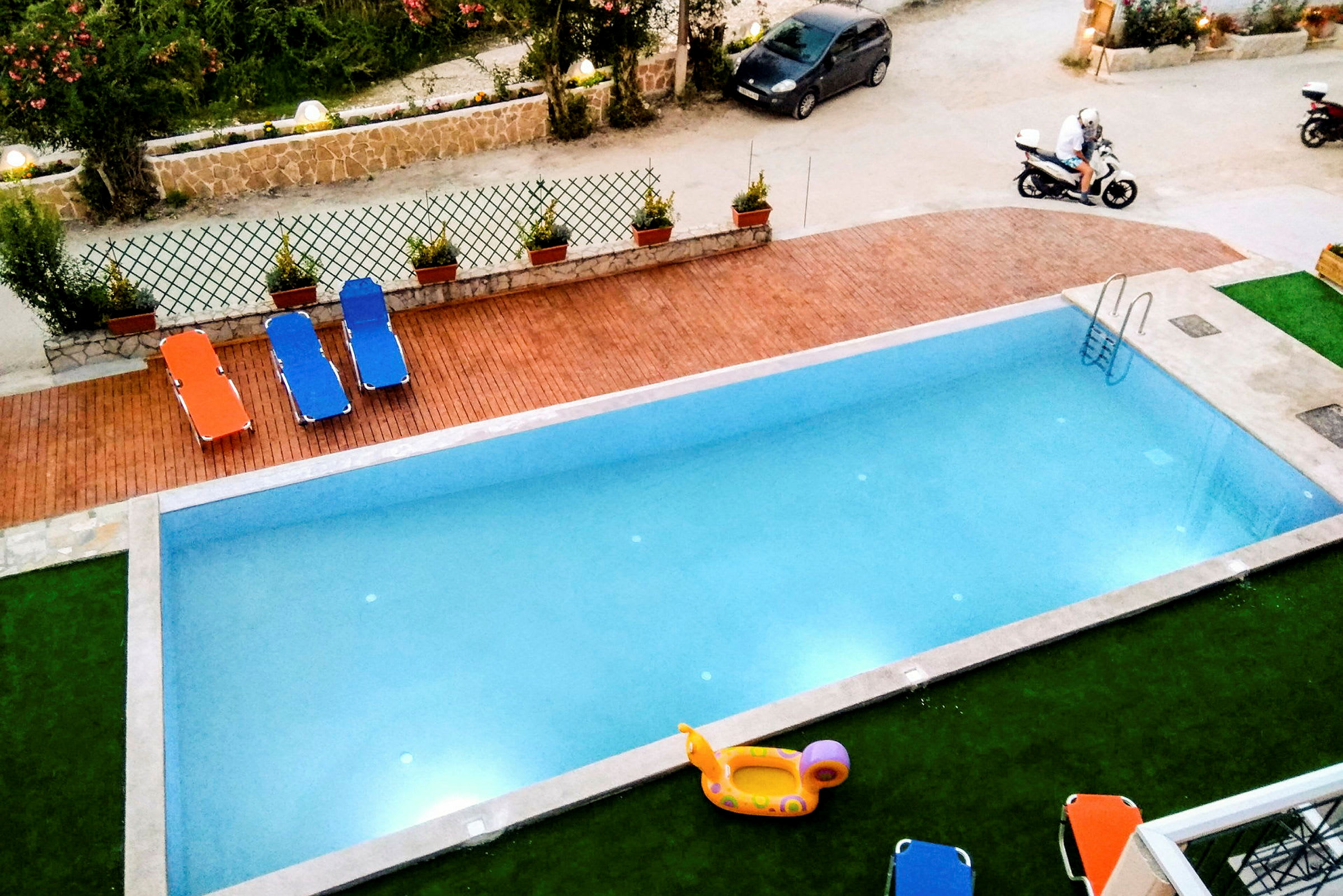 Utomhuspool med solstolar och en uppblåsbar leksak. (AI-genererad text)