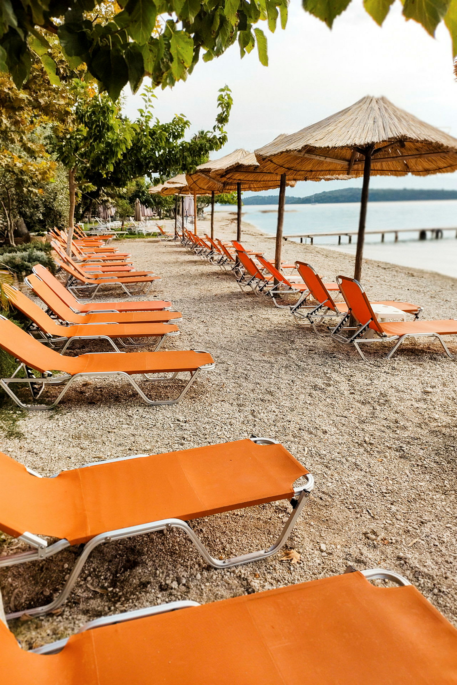 Strand med orange solstolar och parasoller. (AI-genererad text)
