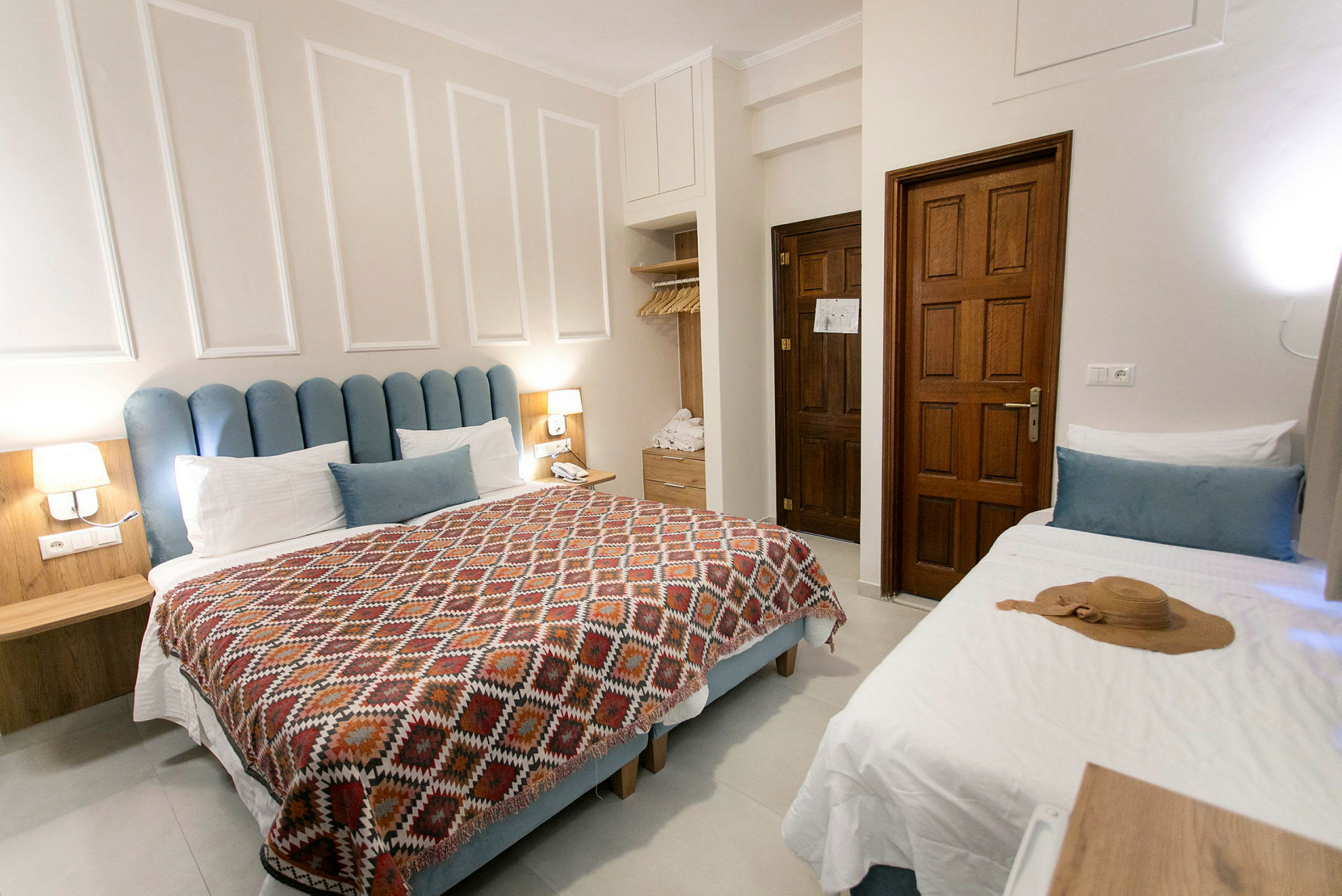 Ett hotellrum med en dubbelsäng, en enkelbädd och träinredning. (AI-genererad text)