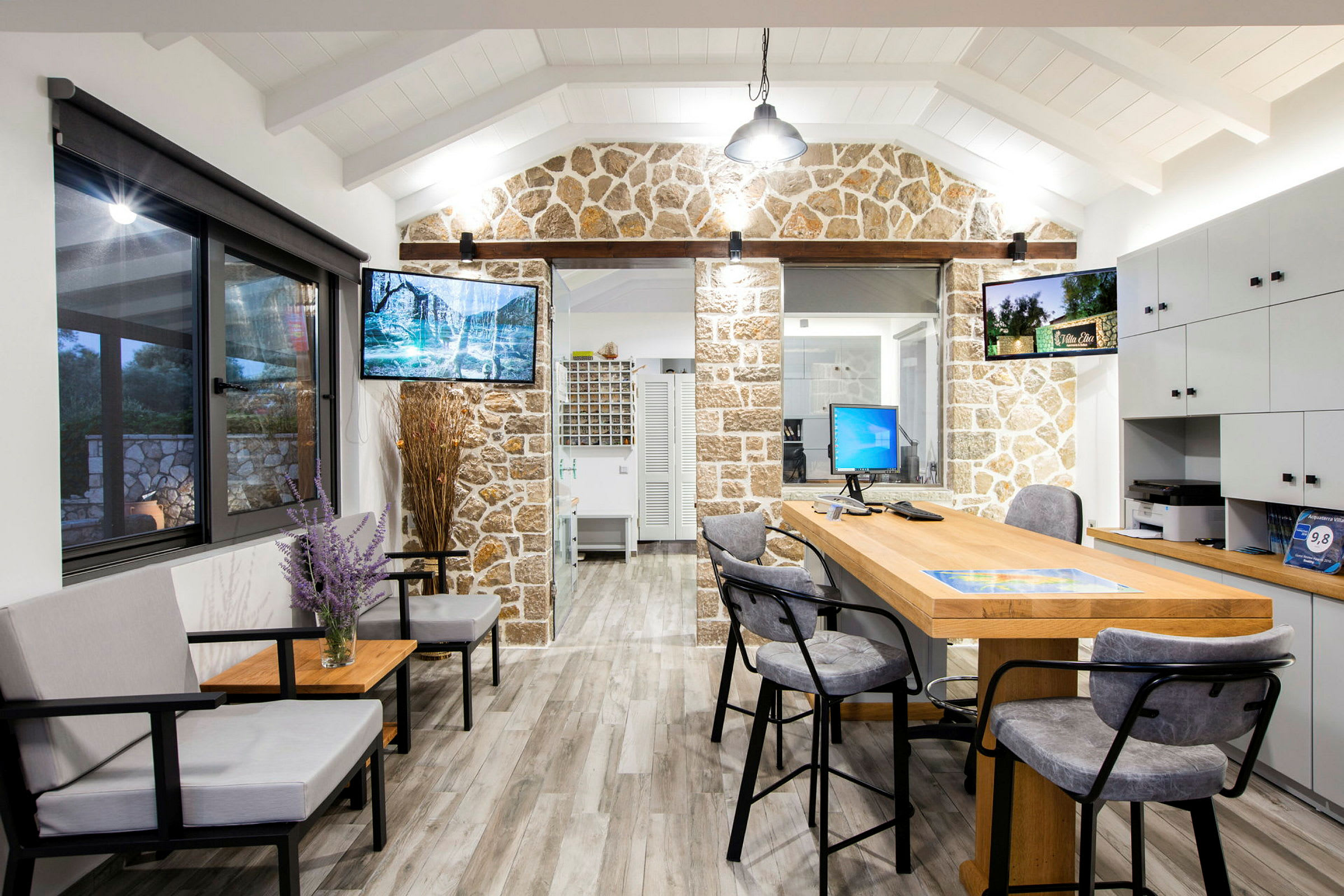 En interiörbild av ett kontor med sittgrupp, skrivbord och dekorativ stenvägg. (AI-genererad text)