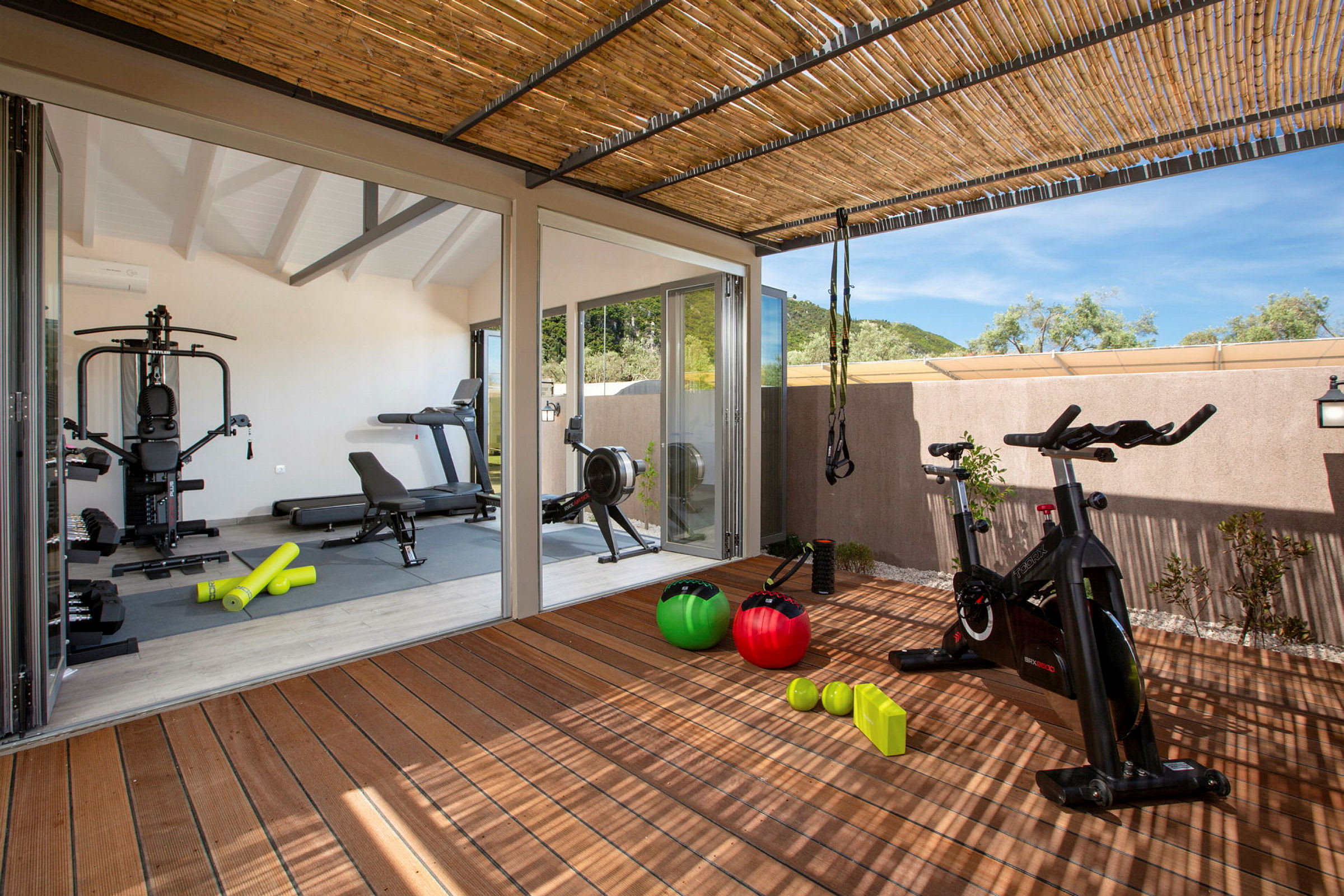Bild av ett gym med träningsutrustning som crosstrainer, yogamattor, hantlar och pilatesbollar. (AI-genererad text)