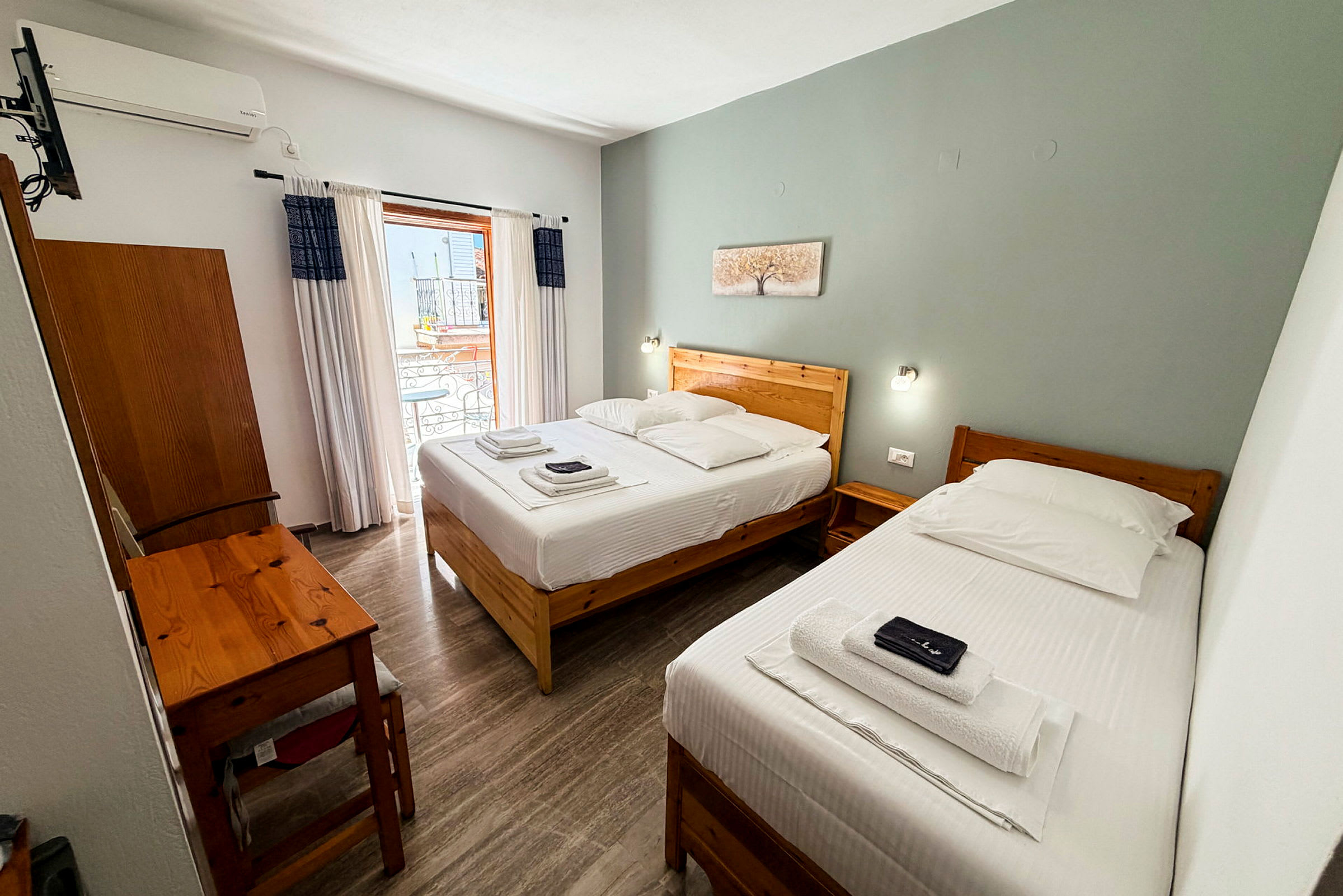 Hotelrum med två enkelsängar, ett skrivbord och en balkong. (AI-genererad text)
