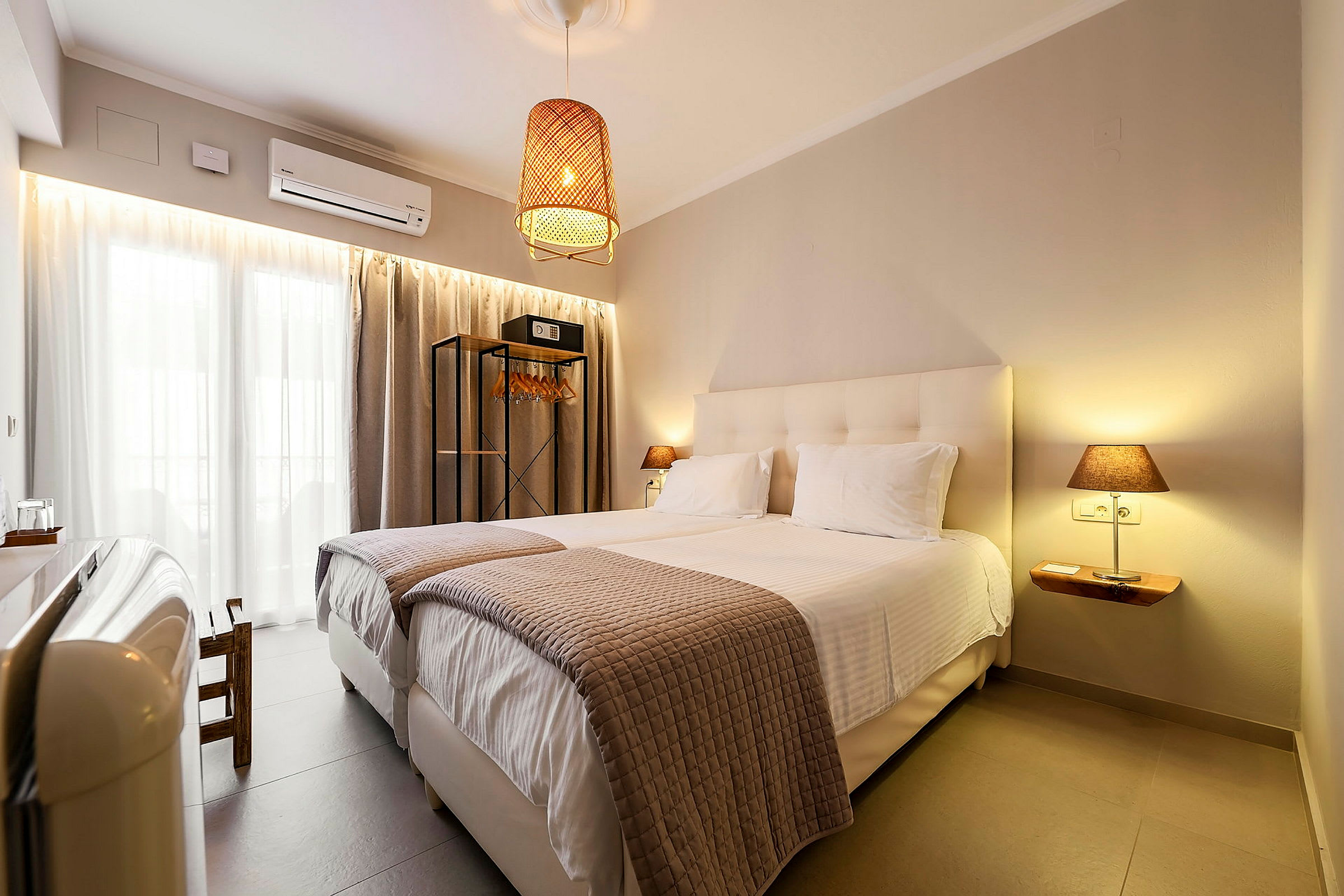 Ett hotellrum med två enkelsängar, modern inredning och en hängande lampa. (AI-genererad text)