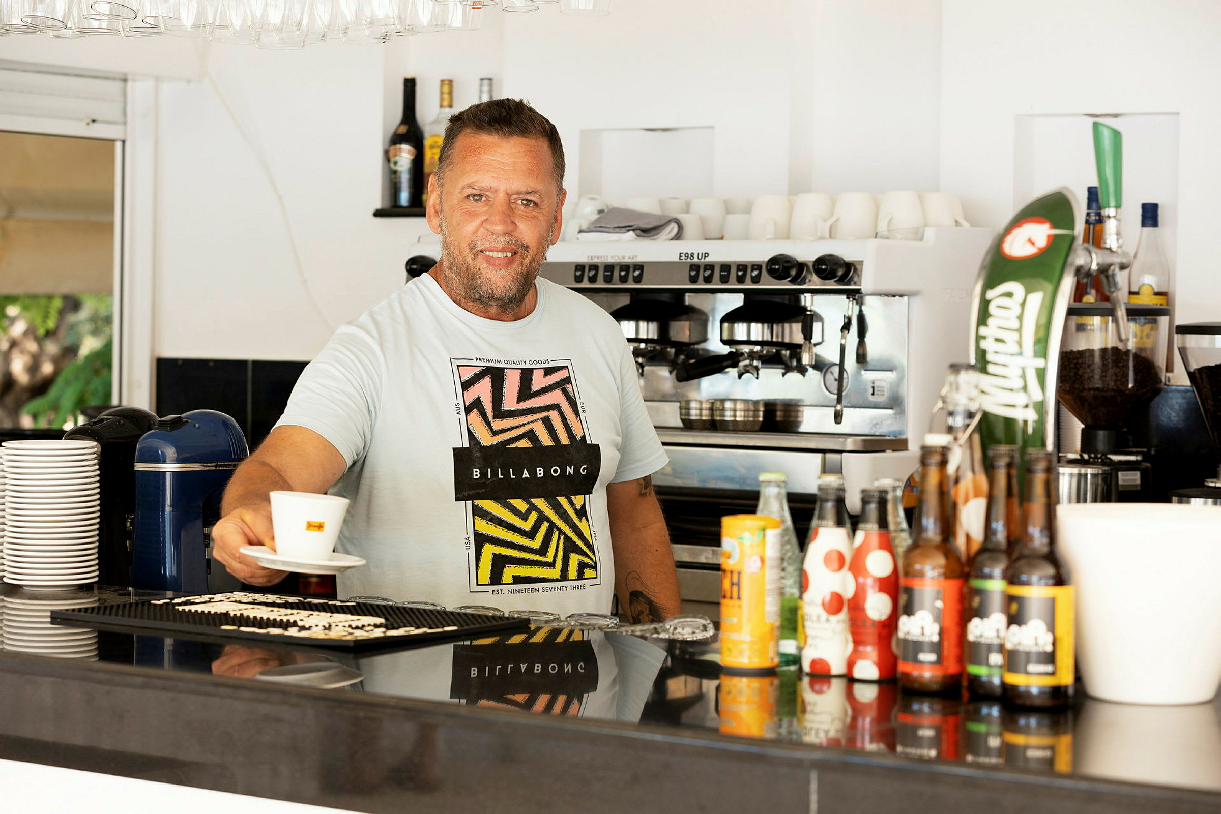 Barområde med kaffemaskin och flaskor på disken. (AI-genererad text)