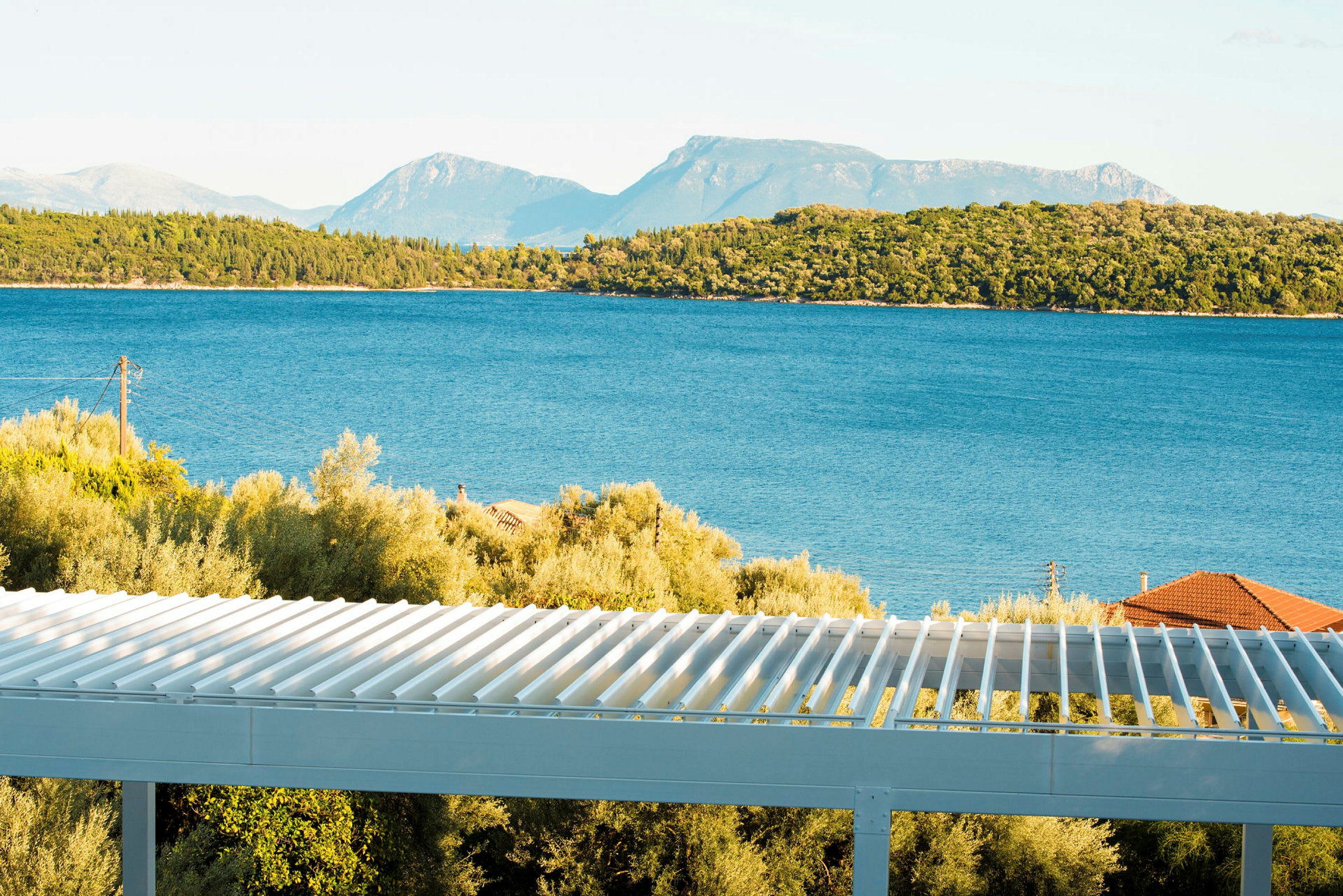 Utsikt över havet med träd och en terrass i förgrunden. (AI-genererad text)