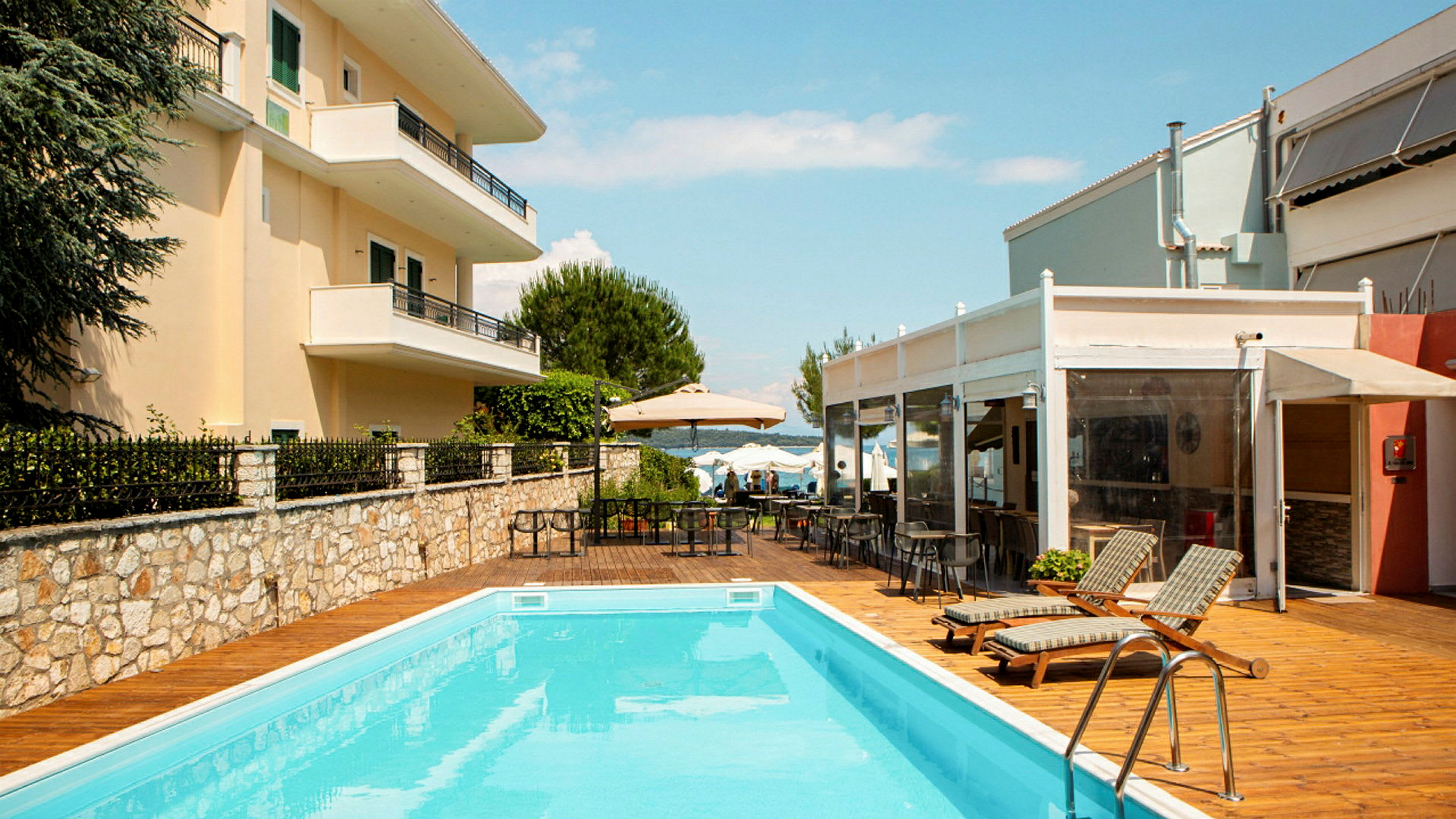 En utomhuspool med solstolar och bord vid ett hotellområde. (AI-genererad text)