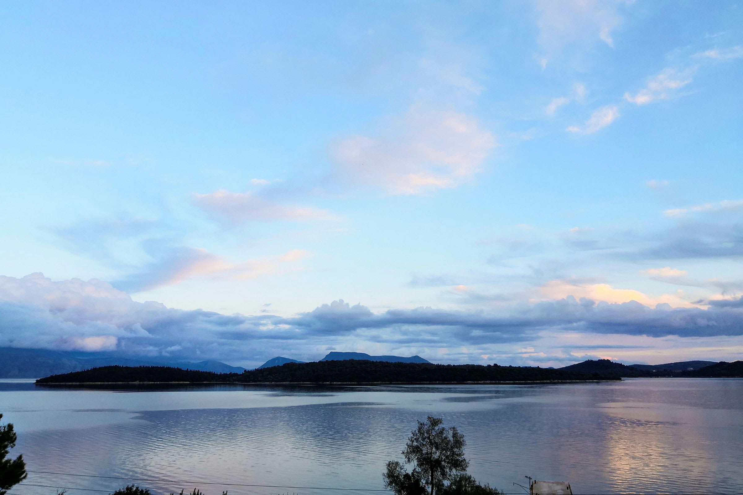 En vy över en sjö med berg i bakgrunden under en klar himmel. (AI-genererad text)