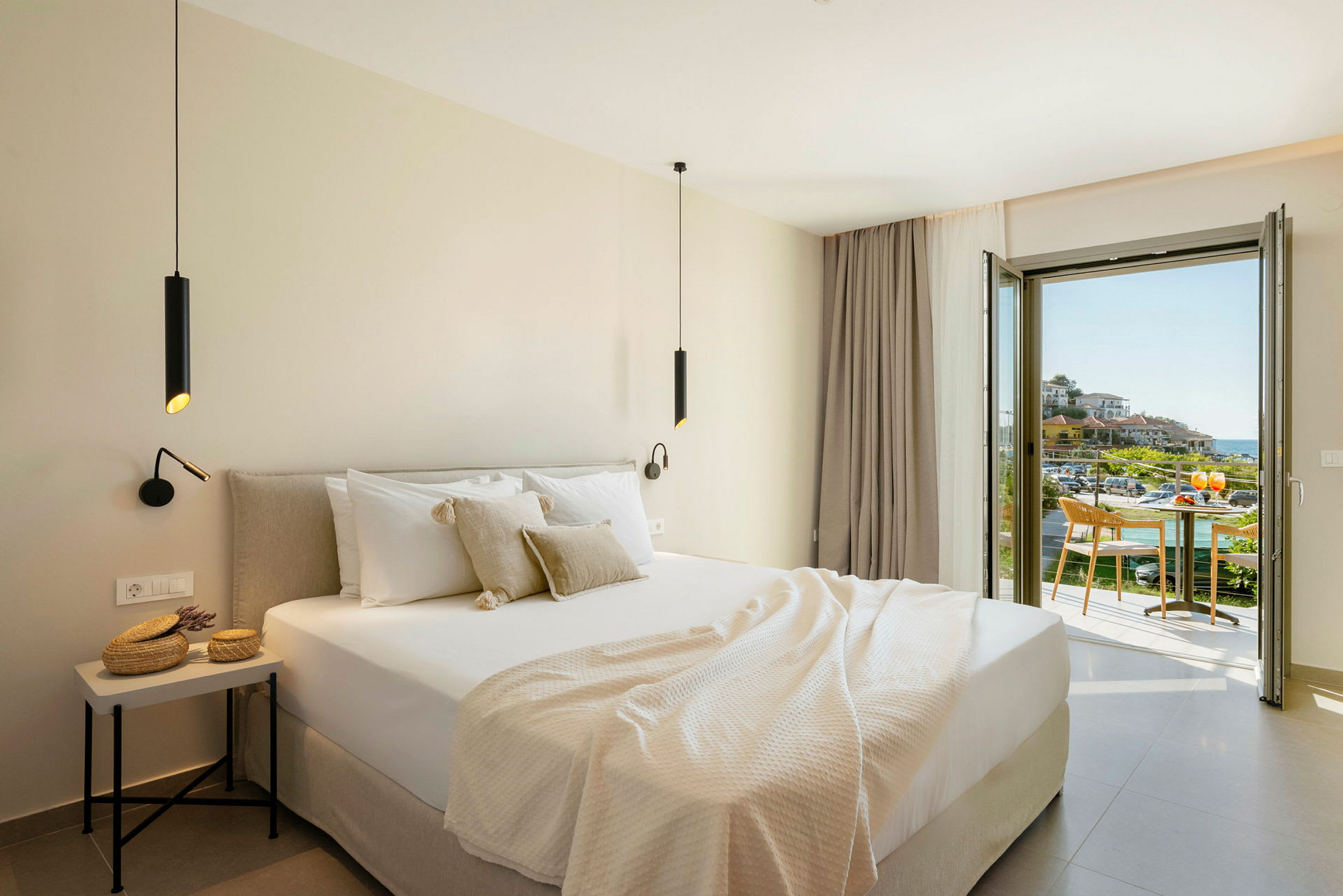 Modernt hotellrum med dubbelsäng och balkong som erbjuder utsikt över en pittoresk miljö. (AI-genererad text)