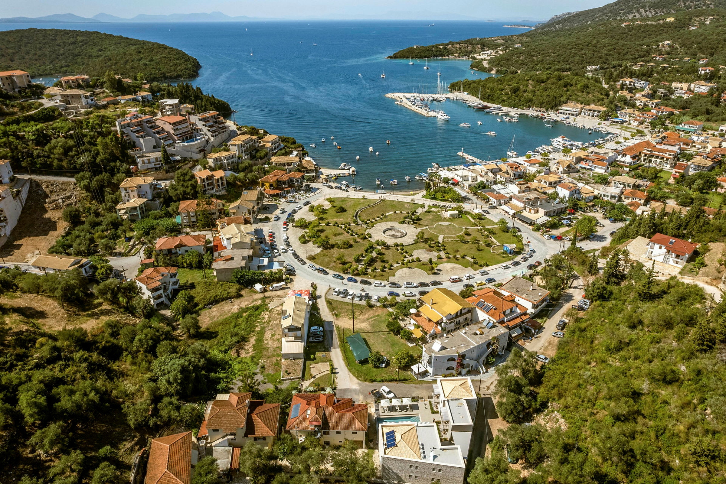 Luftvy av en kuststad med en småbåtshamn vid ett blått hav. (AI-genererad text)