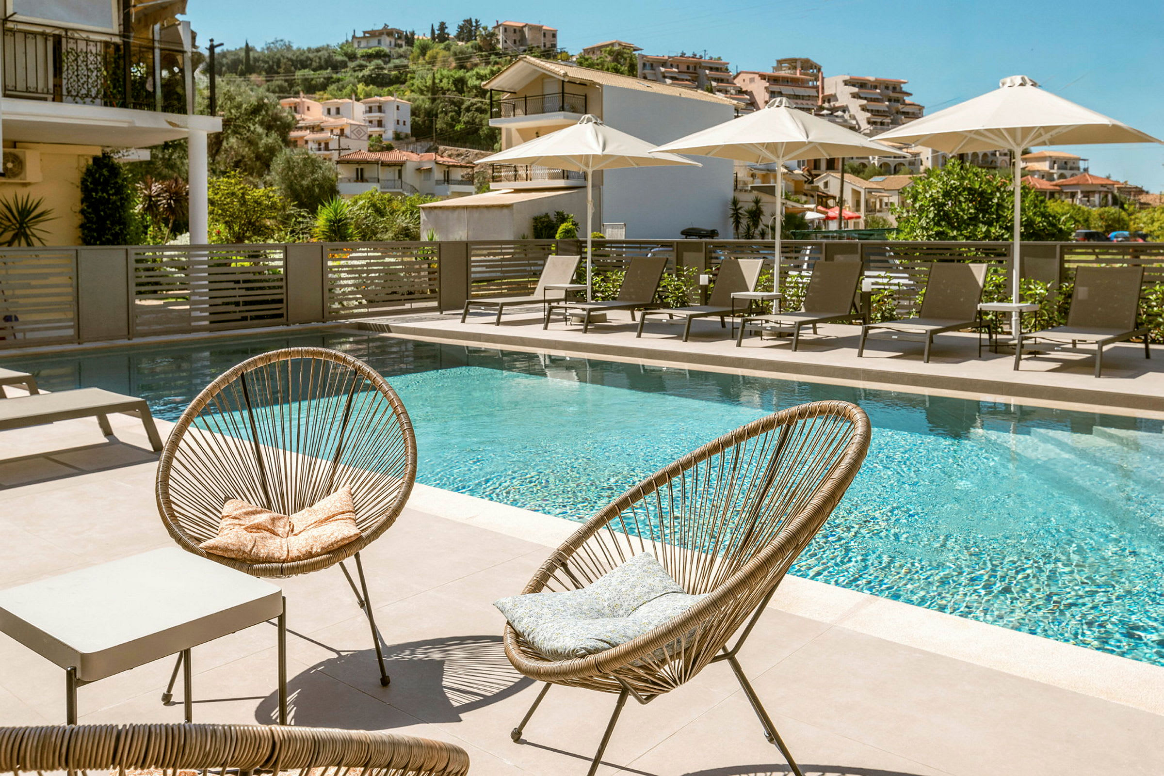 Utemöbler vid en pool med solstolar och parasoller. (AI-genererad text)