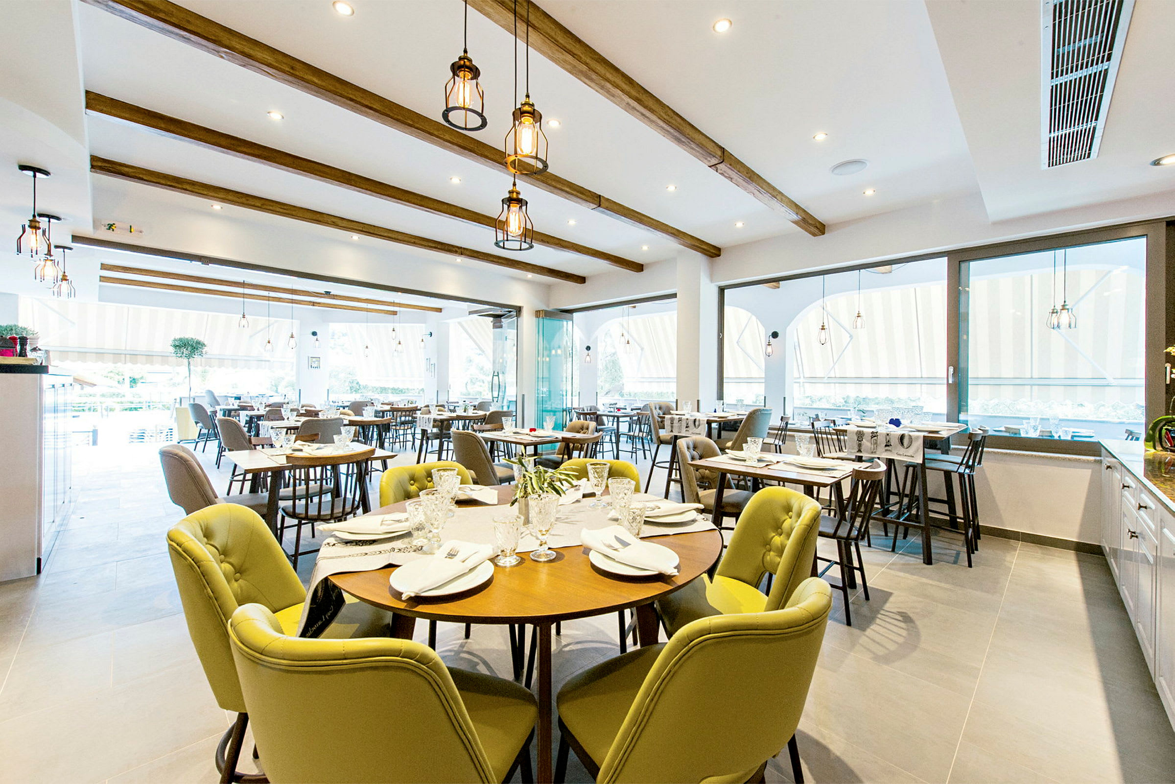 En restaurang med många dukade bord och stolar. (AI-genererad text)
