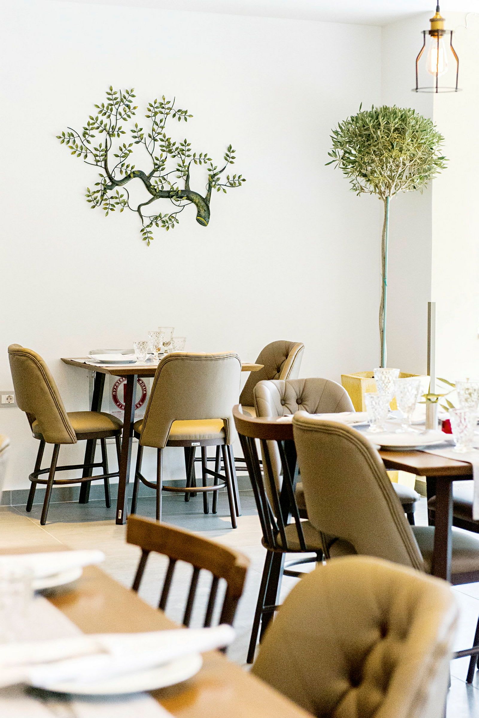 Interiör av en restaurang med dukade bord och stolar. (AI-genererad text)