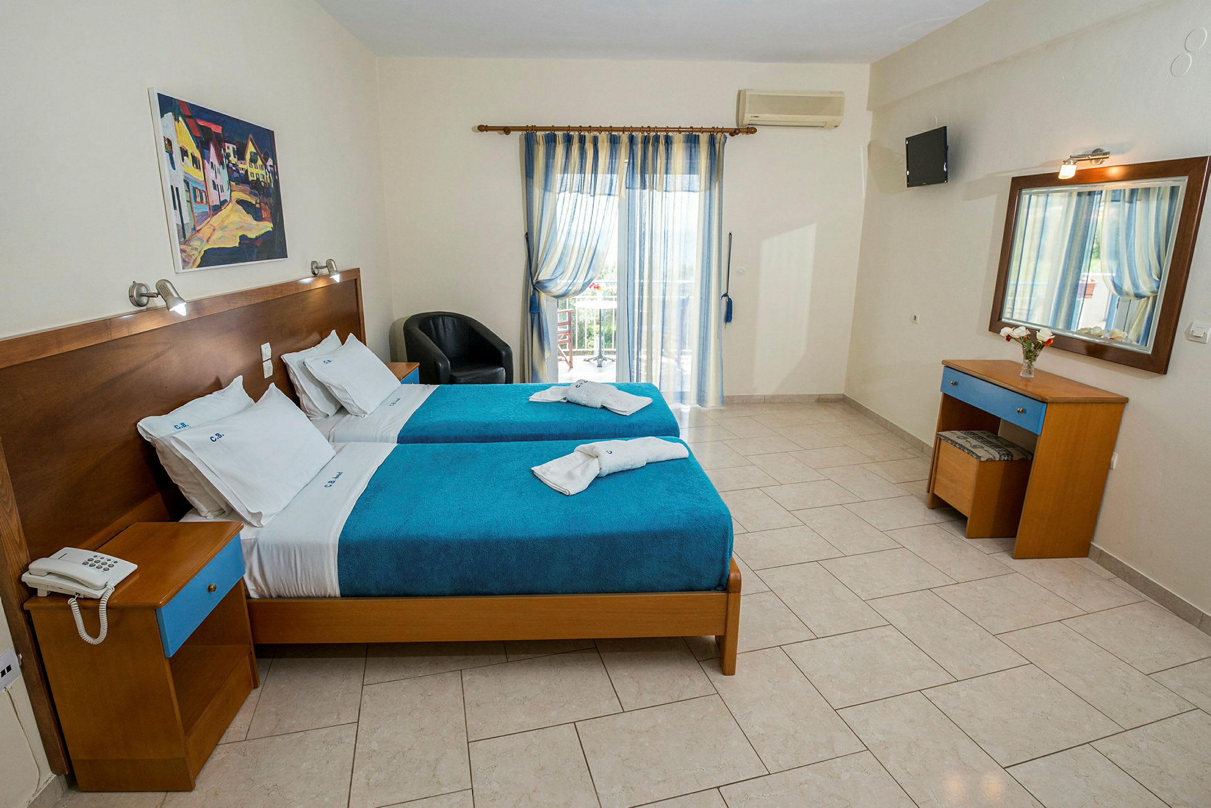 Ett hotellrum med två enkelsängar klädda i blå överkast och vita lakan. (AI-genererad text)
