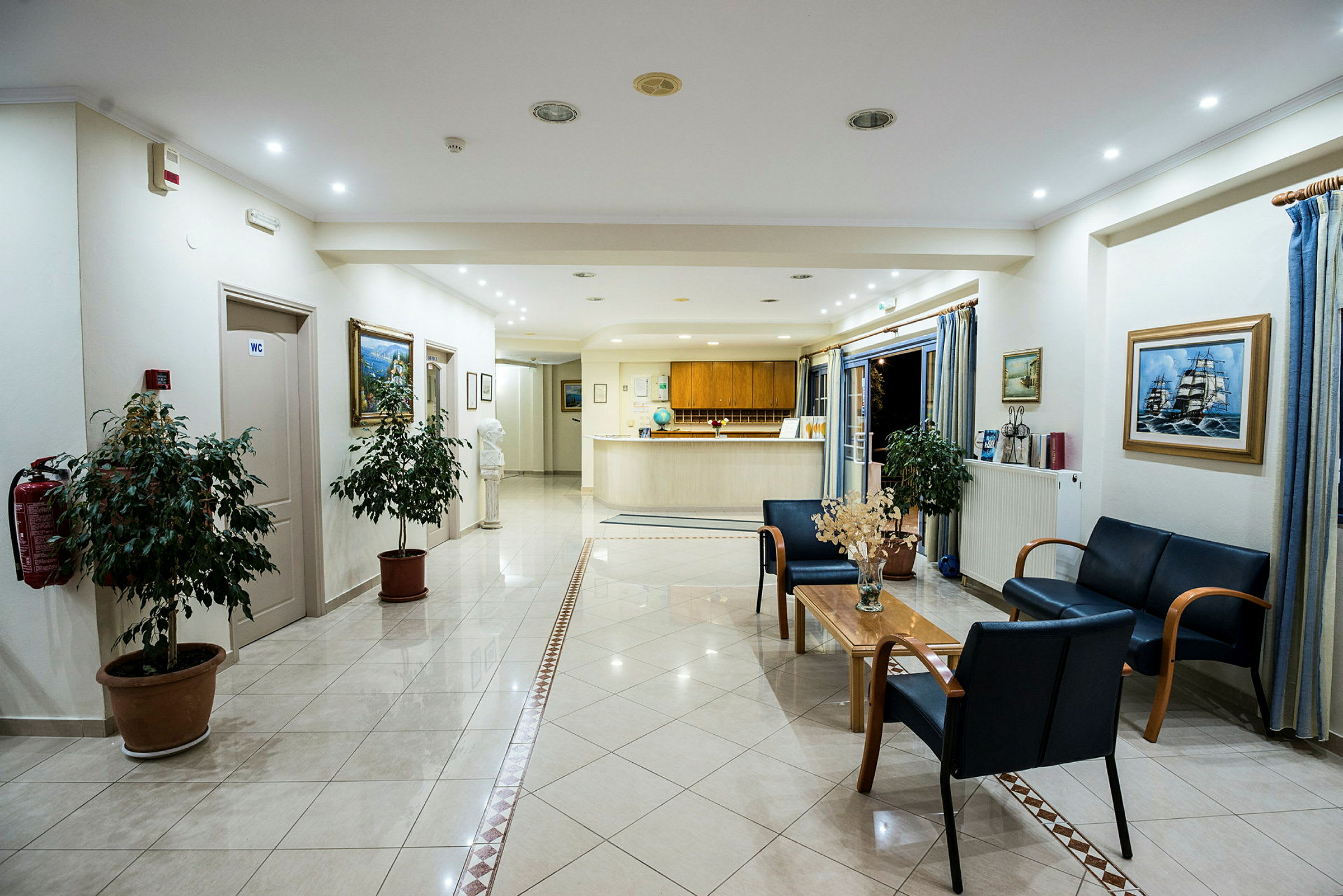 Bild på en hotellobby med reception, sittgrupp och dekorativa växter. (AI-genererad text)