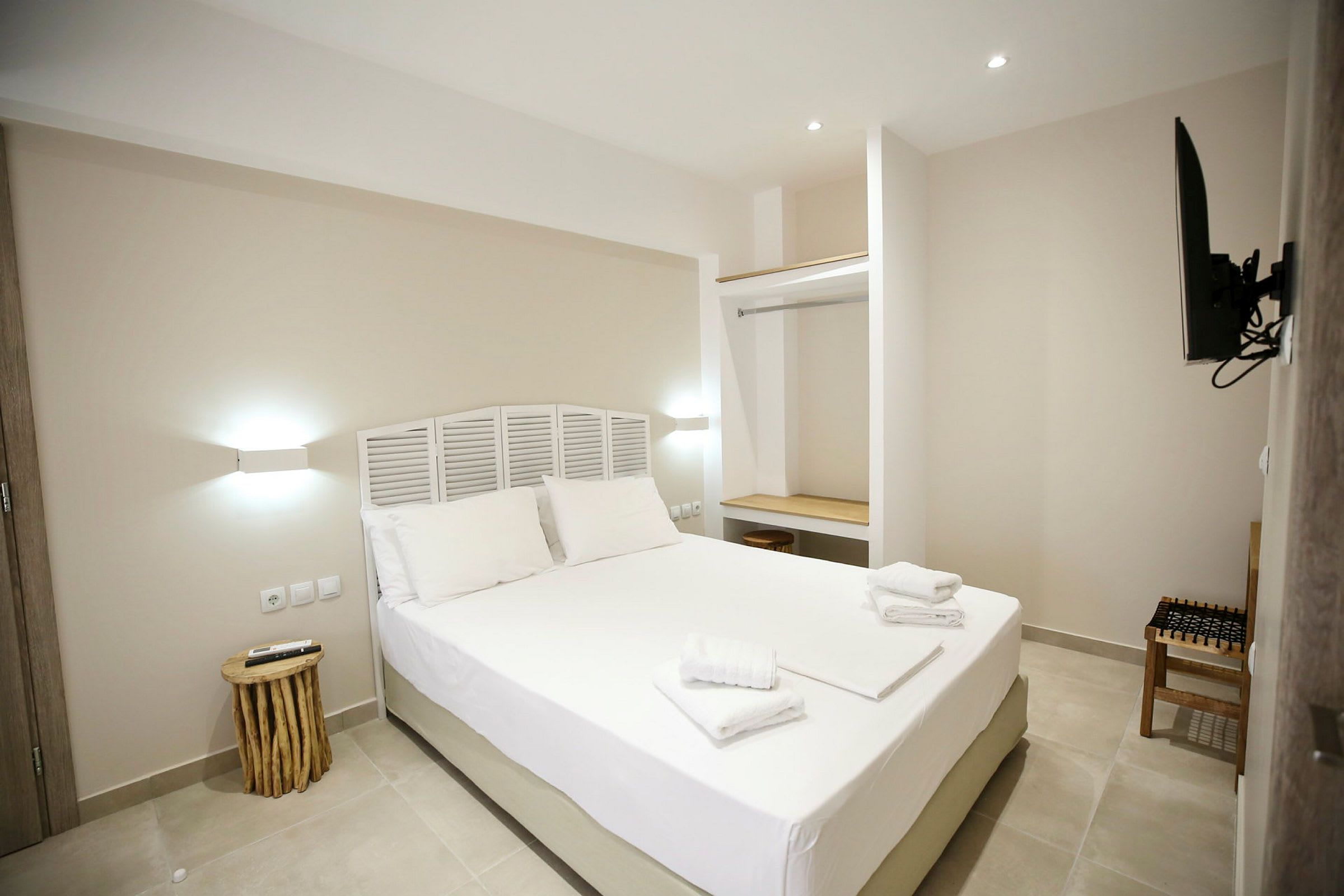 Moderna hotellrum med en dubbelsäng, minimalistisk inredning och vita väggar. (AI-genererad text)