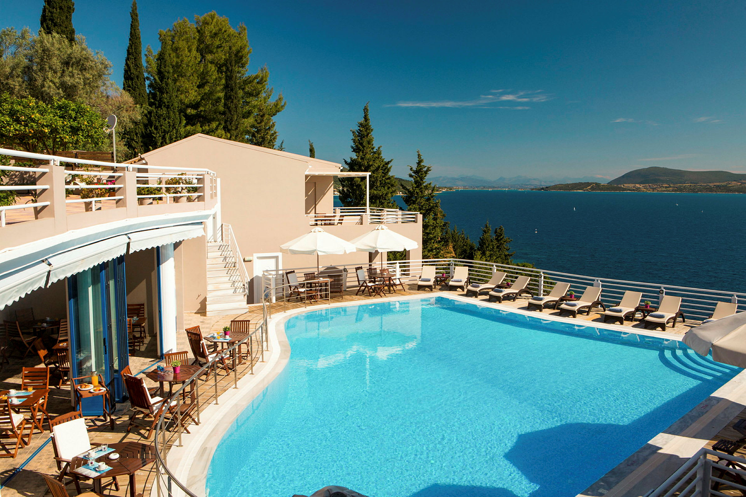 Hotellpool med solstolar och utsikt över havet. (AI-genererad text)