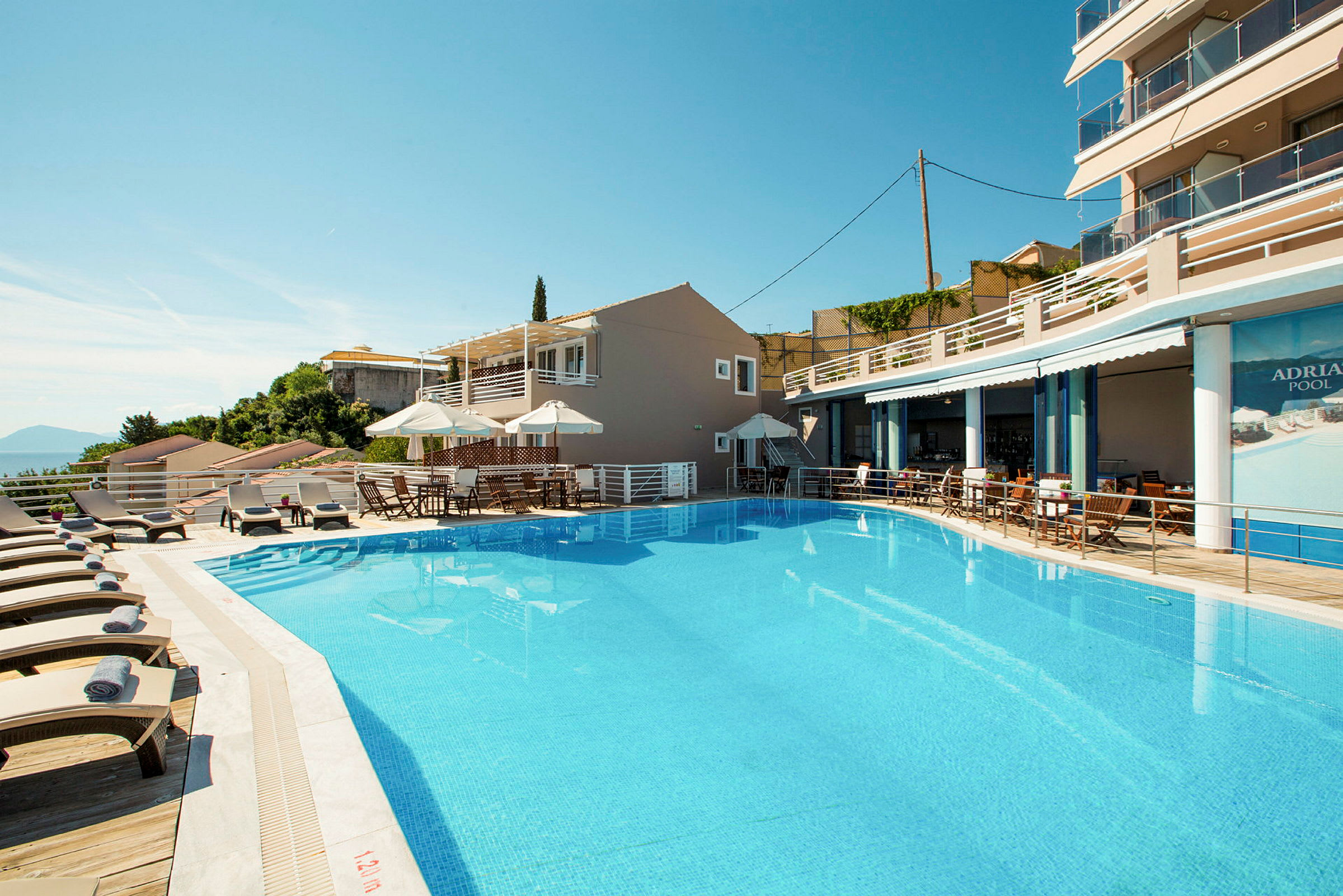 Bild av en utomhuspool med solstolar och parasoller vid ett hotell. (AI-genererad text)