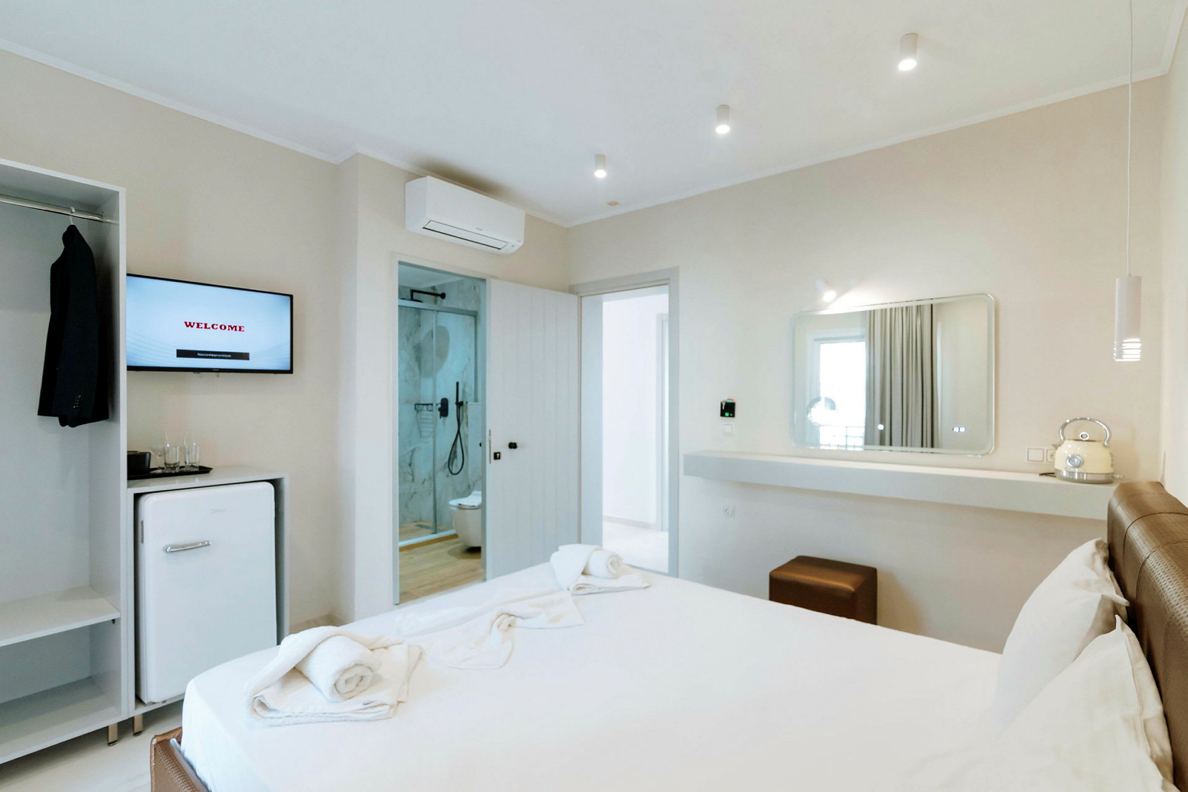 Modern hotellrum med säng, spegel, och badrum. (AI-genererad text)