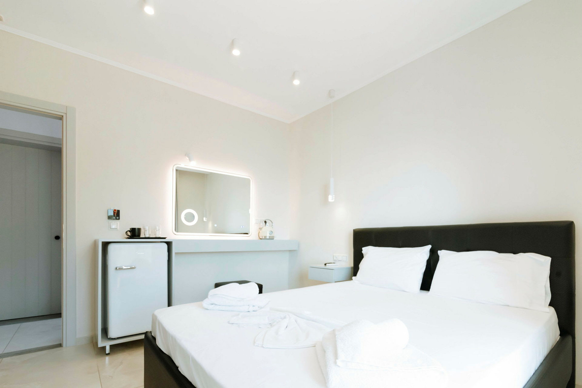 Ett hotellrum med en dubbelsäng och en spegel ovanför en hylla. (AI-genererad text)