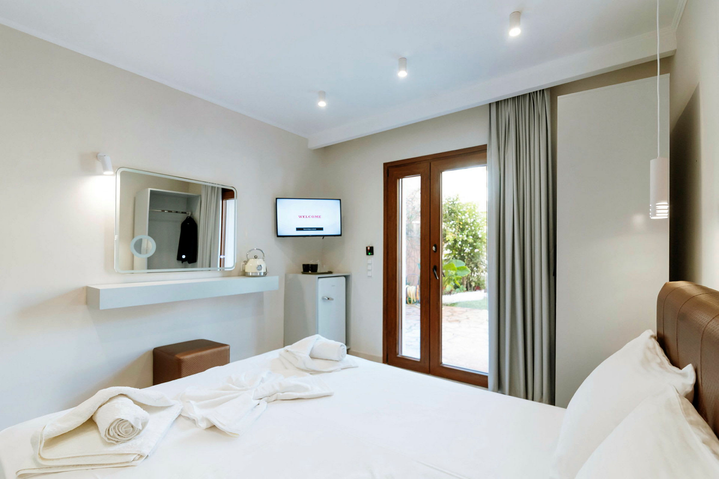 Modernt hotellrum med en dubbelsäng och utsikt mot trädgården. (AI-genererad text)