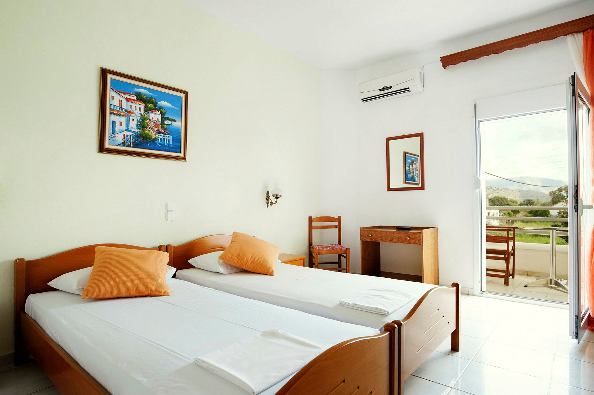 Hotellrum med två enkelsängar, en skrivbord med stol och balkong med utsikt. (AI-genererad text)
