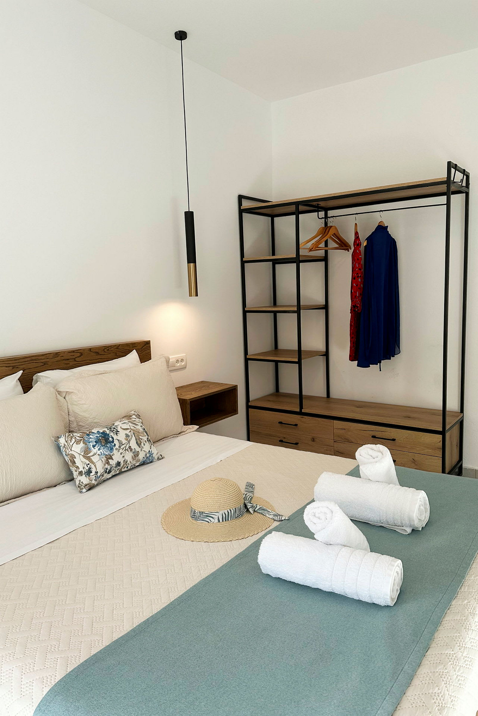 Ett hotellrum med säng, handdukar och garderob. (AI-genererad text)