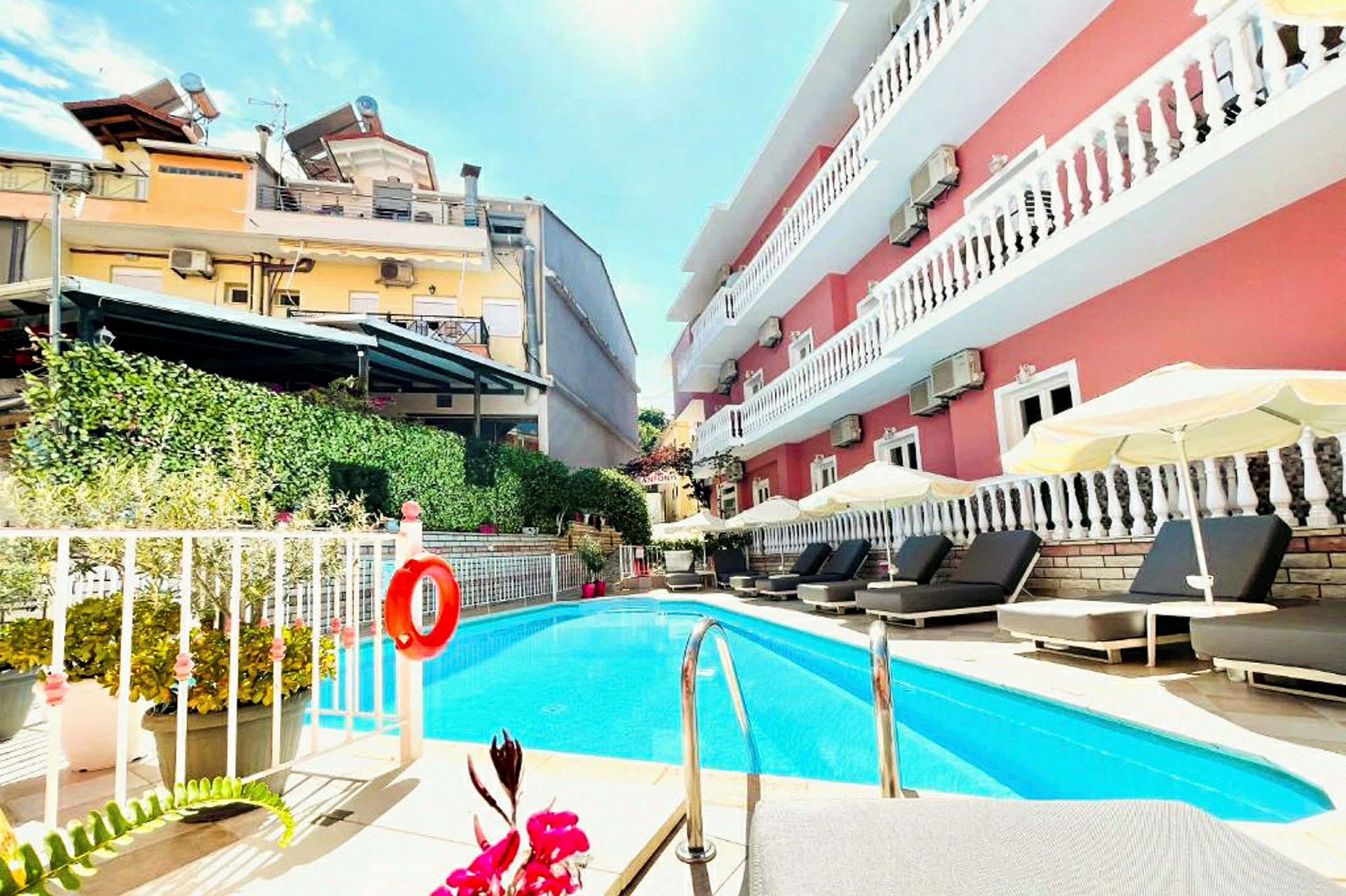 Utomhuspool vid ett hotell med solstolar och parasoller. (AI-genererad text)