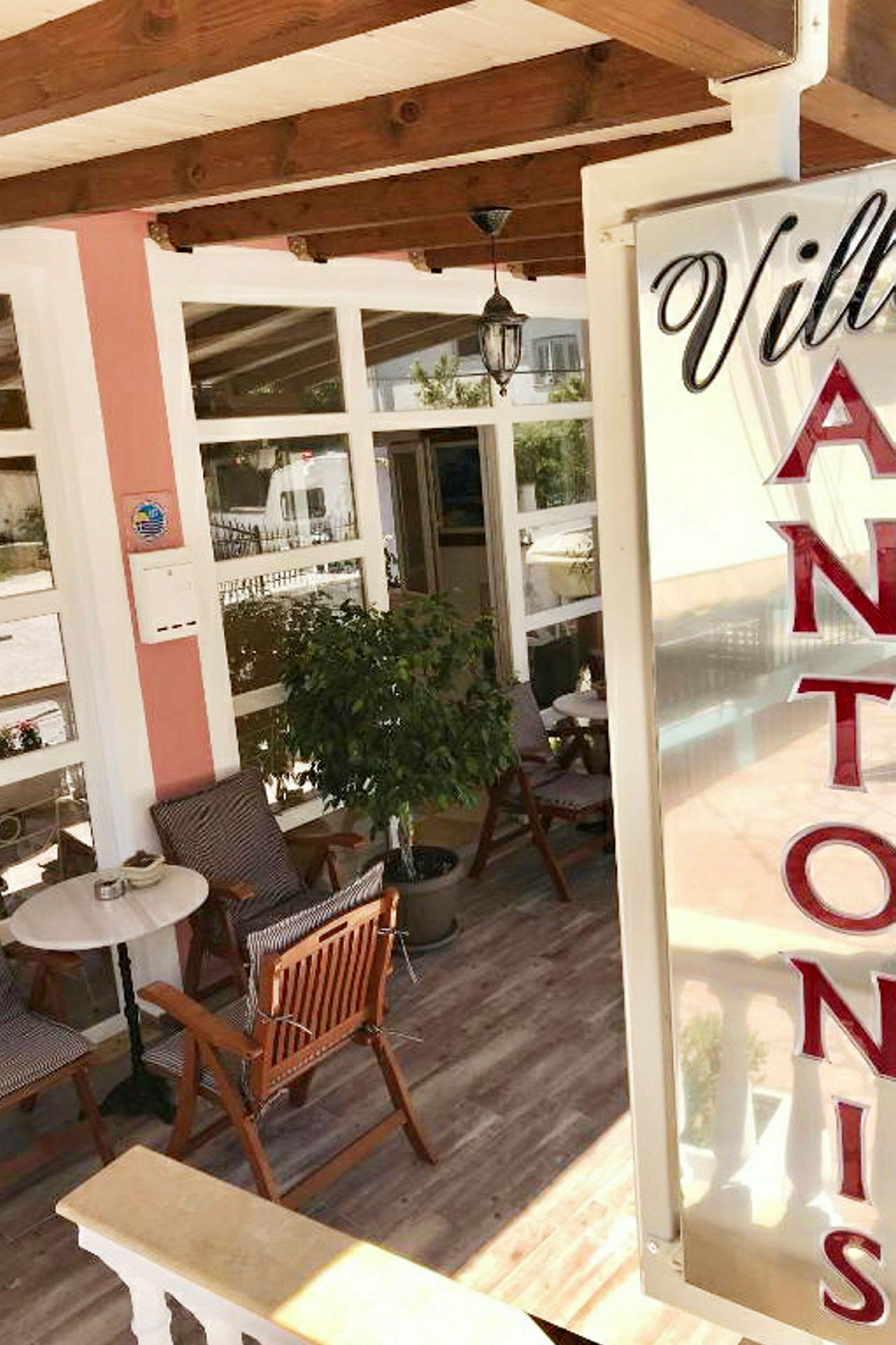 Entréområdet till Villa Antonis med sittgrupp och dekorationer. (AI-genererad text)