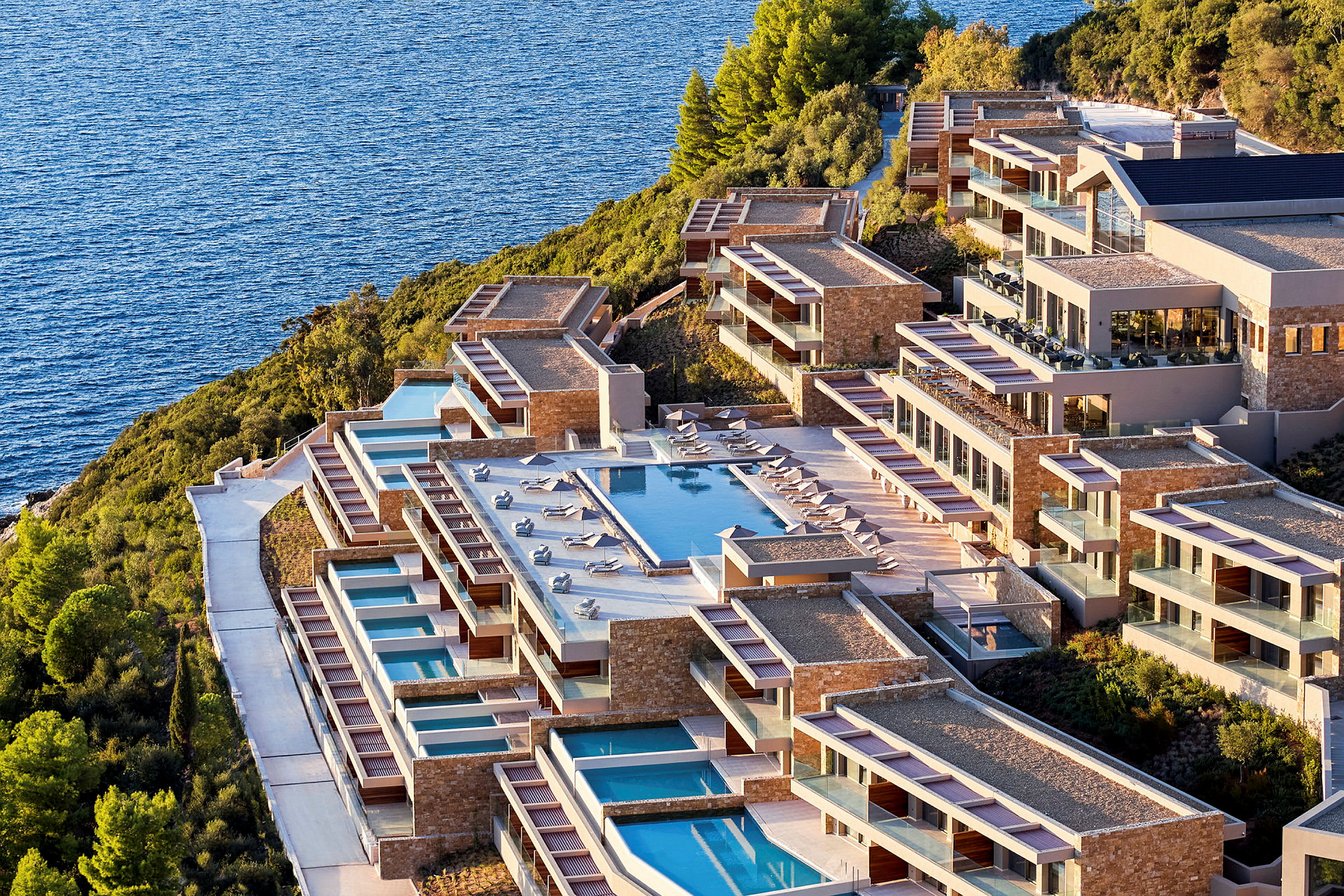 Bild av ett hotellkomplex med pooler, beläget vid havet. (AI-genererad text)