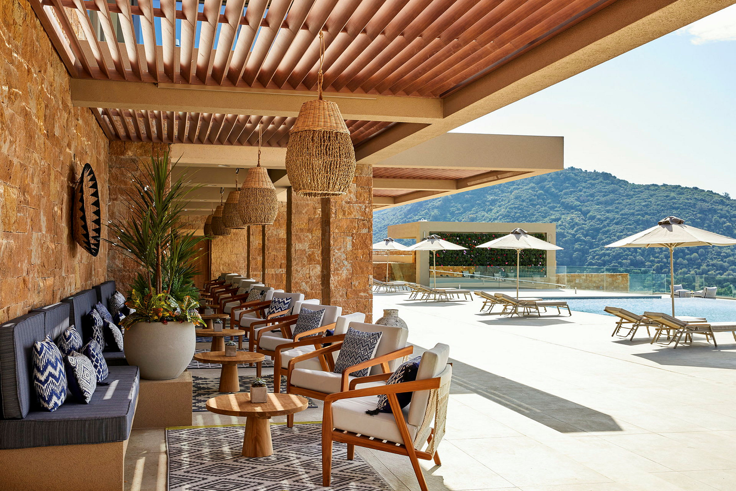 Loungeområde med sittmöbler och utsikt över en pool och grönska. (AI-genererad text)
