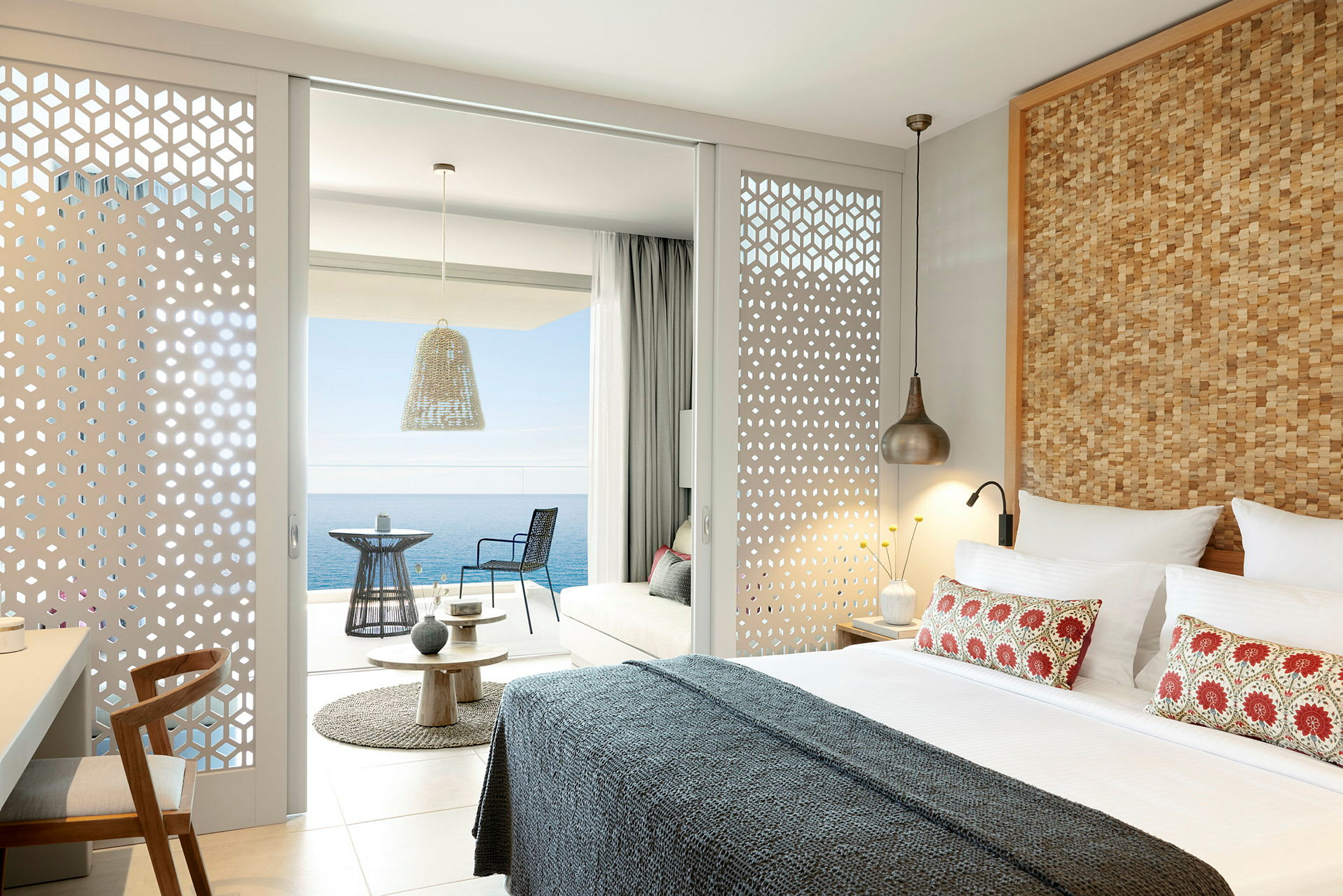 Modernt inrett hotellrum med utsikt över havet från en möblerad balkong. (AI-genererad text)