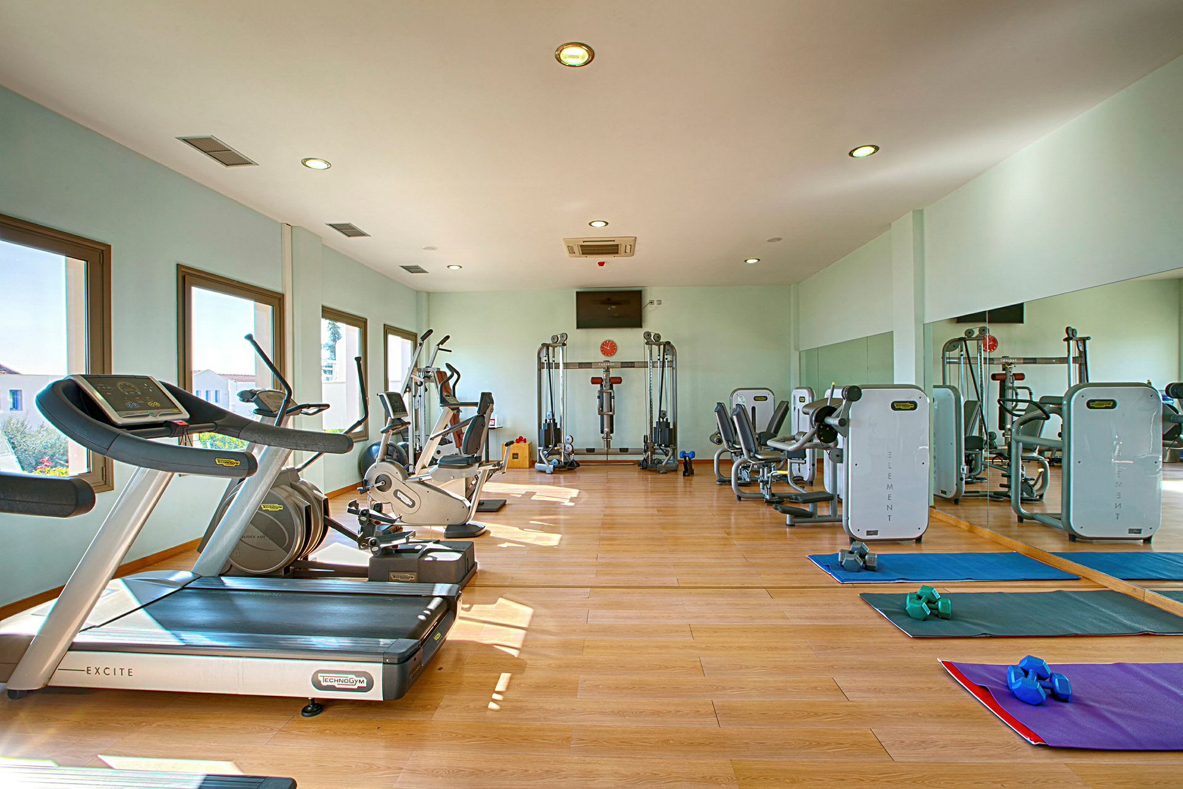 Ett gym med träningsmaskiner, löpband och träningsmattor. (AI-genererad text)