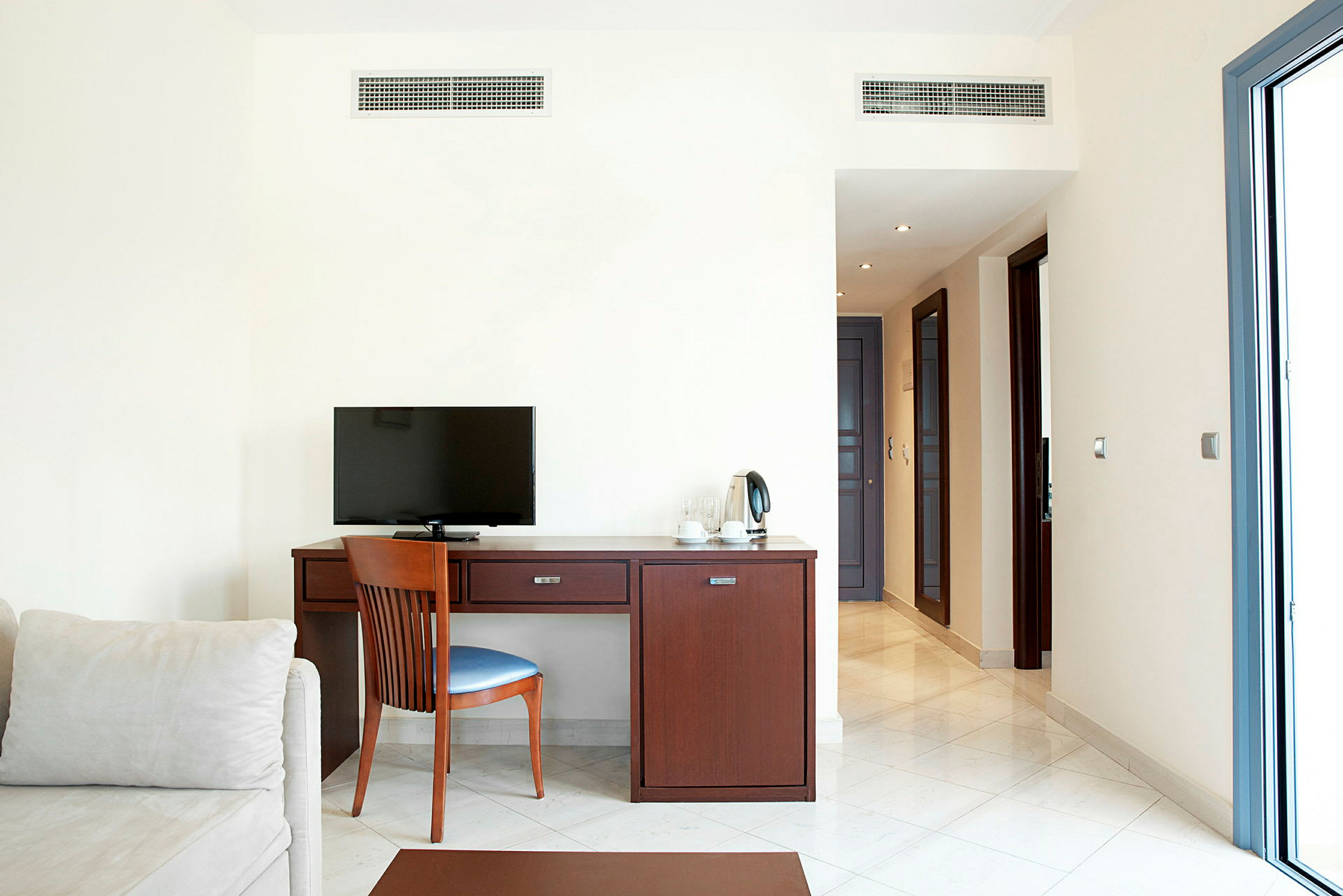 Hotellrum med skrivbord, stol och TV. (AI-genererad text)
