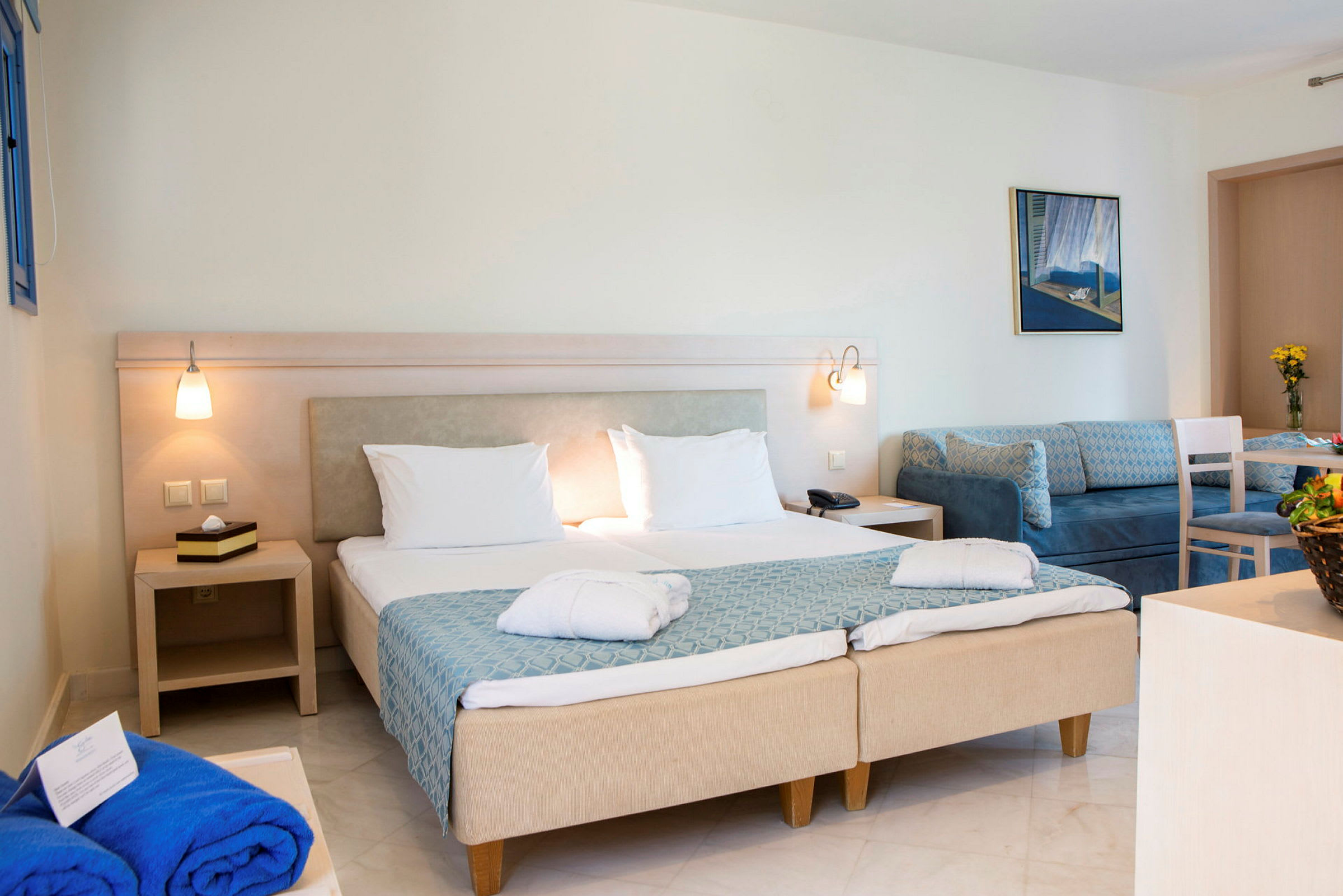 Ett hotellrum med två sängar, soffhörna och bord. (AI-genererad text)