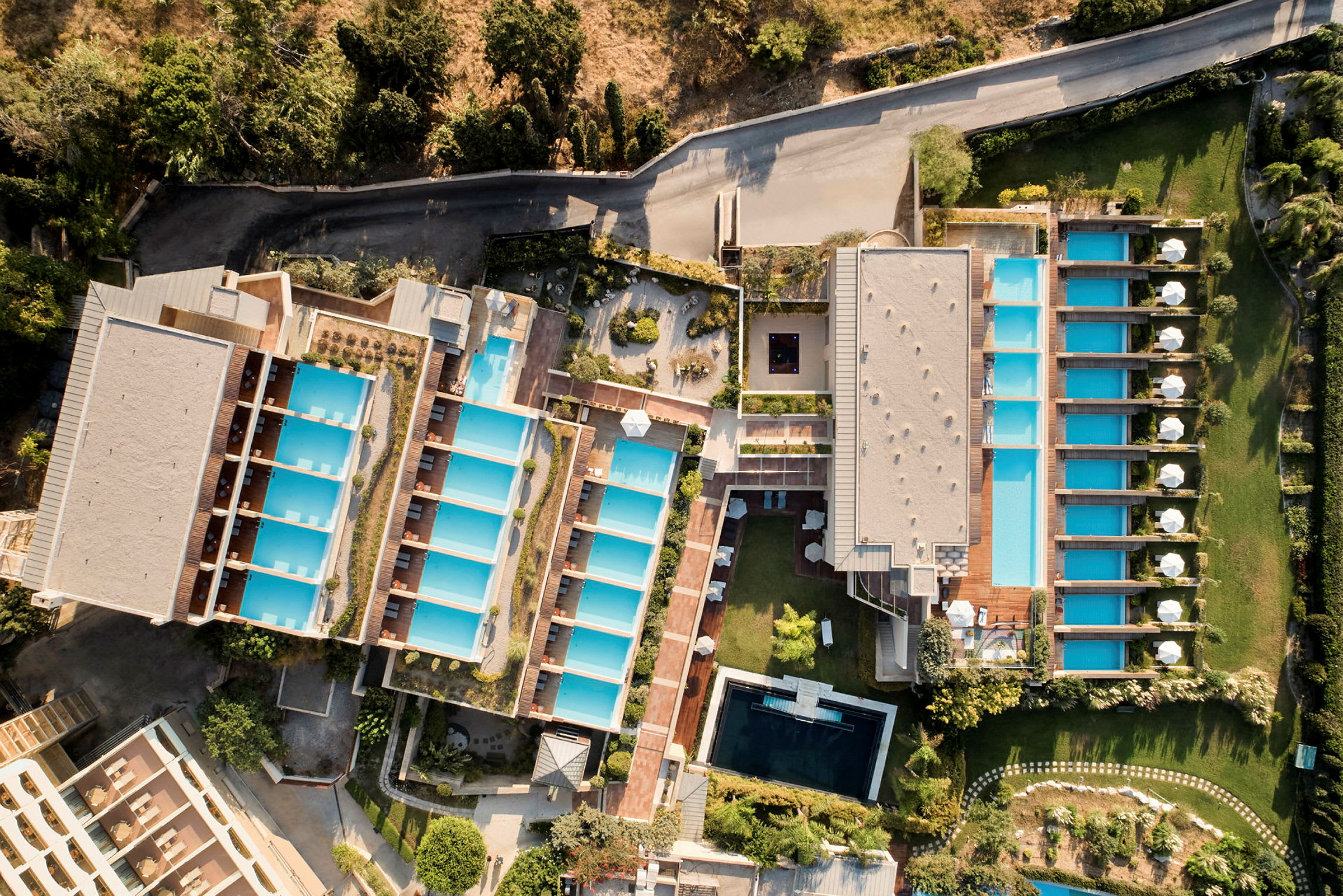 Flygfoto av en hotellanläggning med flera swimmingpooler. (AI-genererad text)