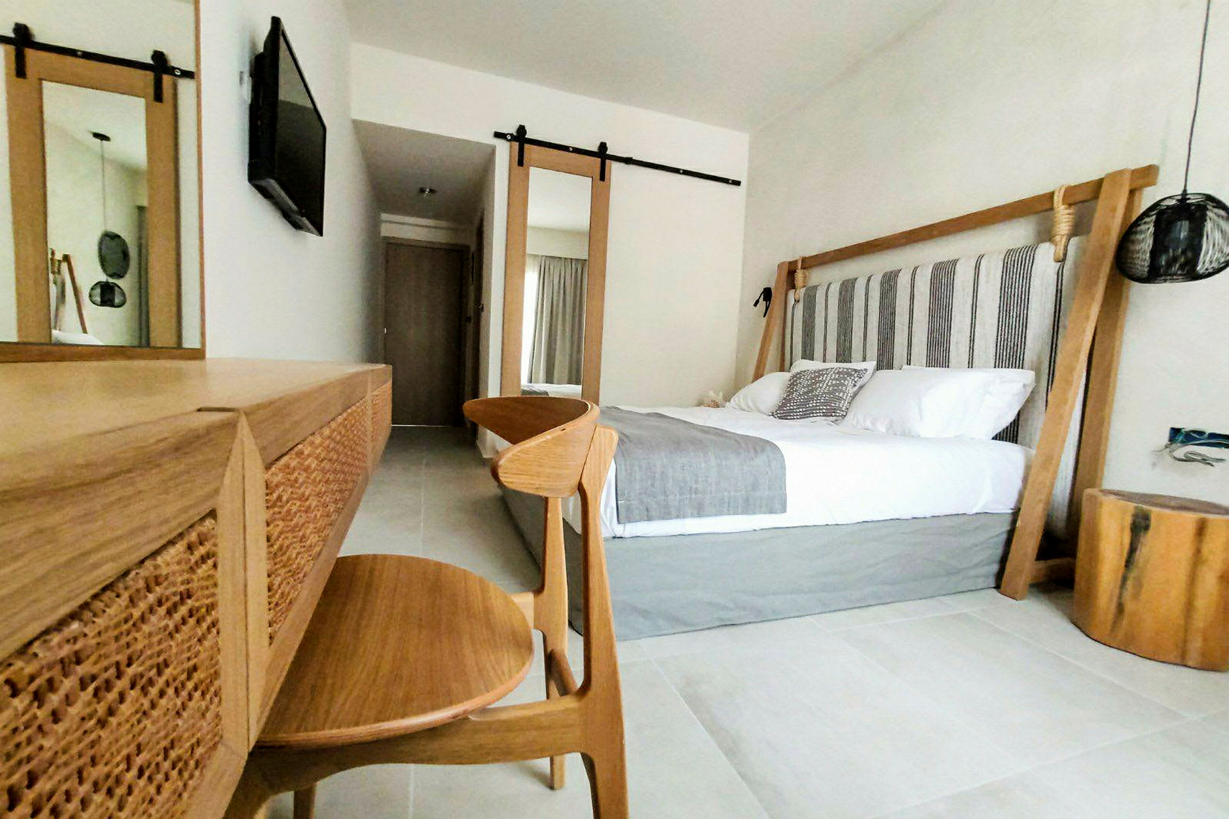 Modern hotellrumsinteriör med dubbelsäng och träinredning. (AI-genererad text)
