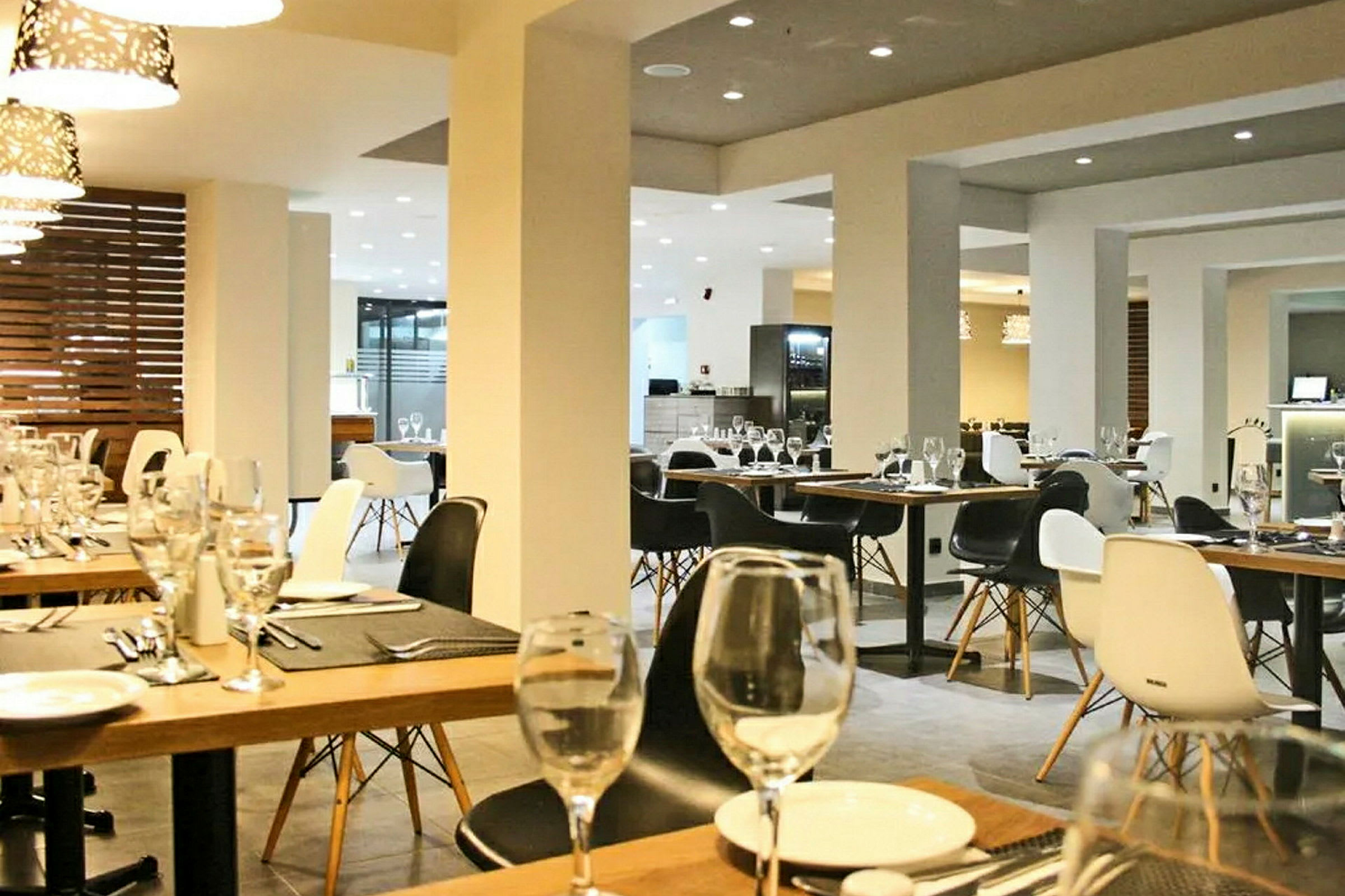 Bild på en modern restauranginteriör med uppdukade bord och elegant belysning. (AI-genererad text)
