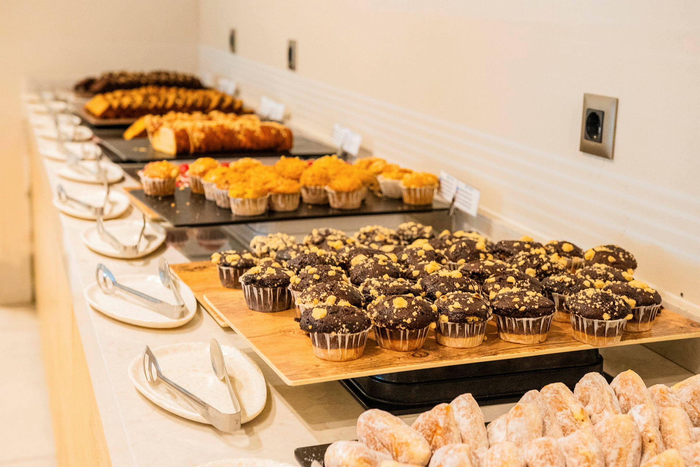 Ett bord med olika typer av bakverk, inklusive chokladmuffins och kakor, arrangerade på fat. (AI-genererad text)