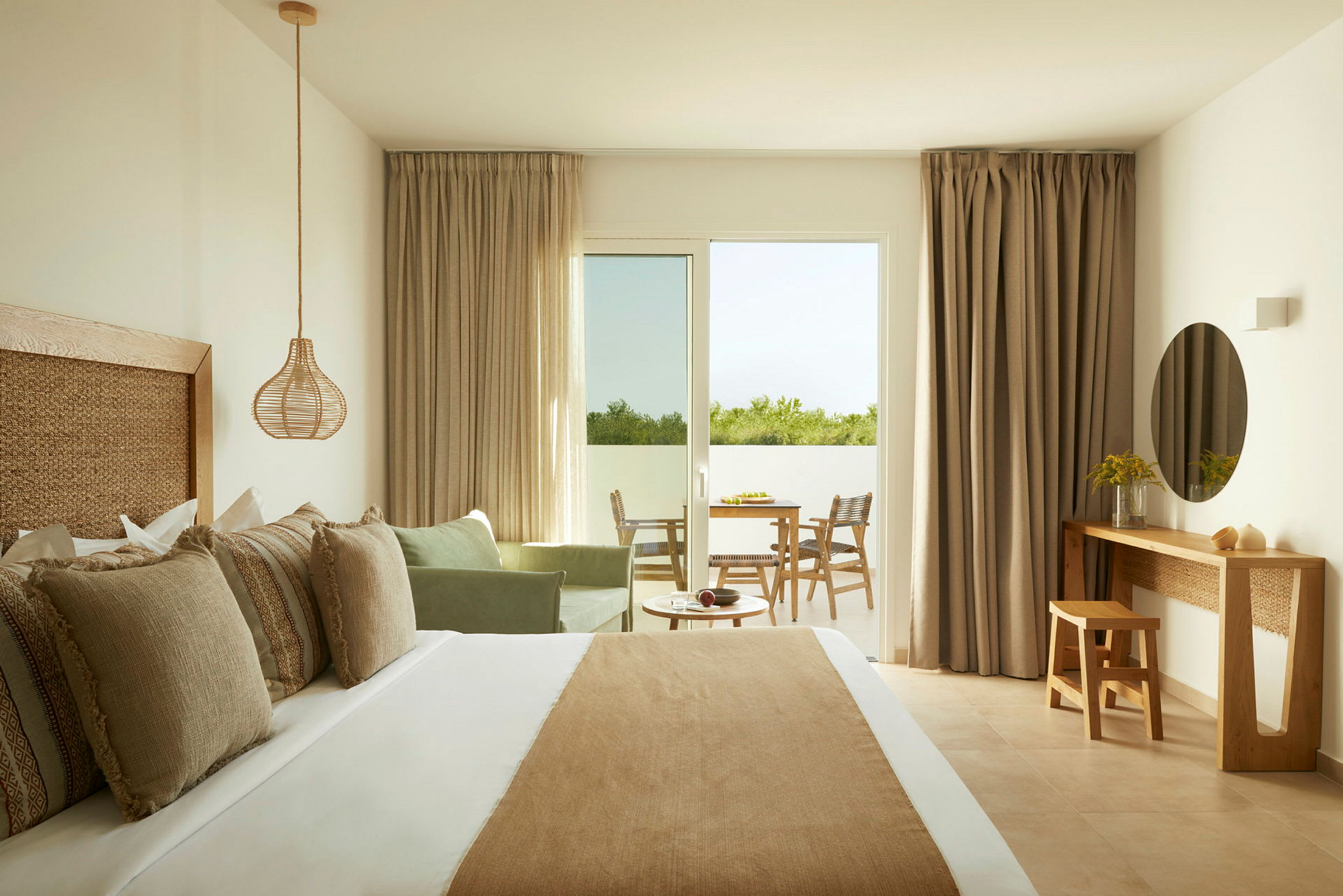 Ett hotellrum med en dubbelsäng, en sittgrupp, ett skrivbord och en utgång till en balkong. (AI-genererad text)