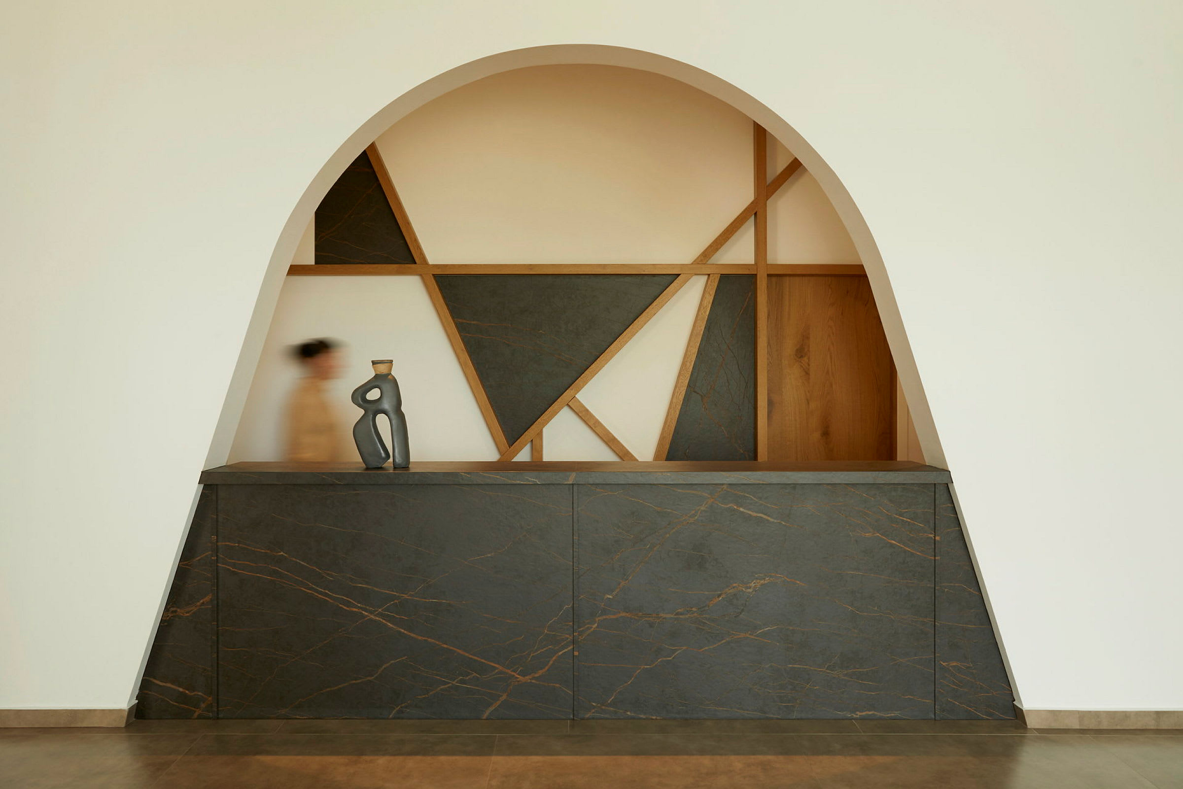 En reception med modern design, geometriska former och en konstnärlig skulptur på disken. (AI-genererad text)