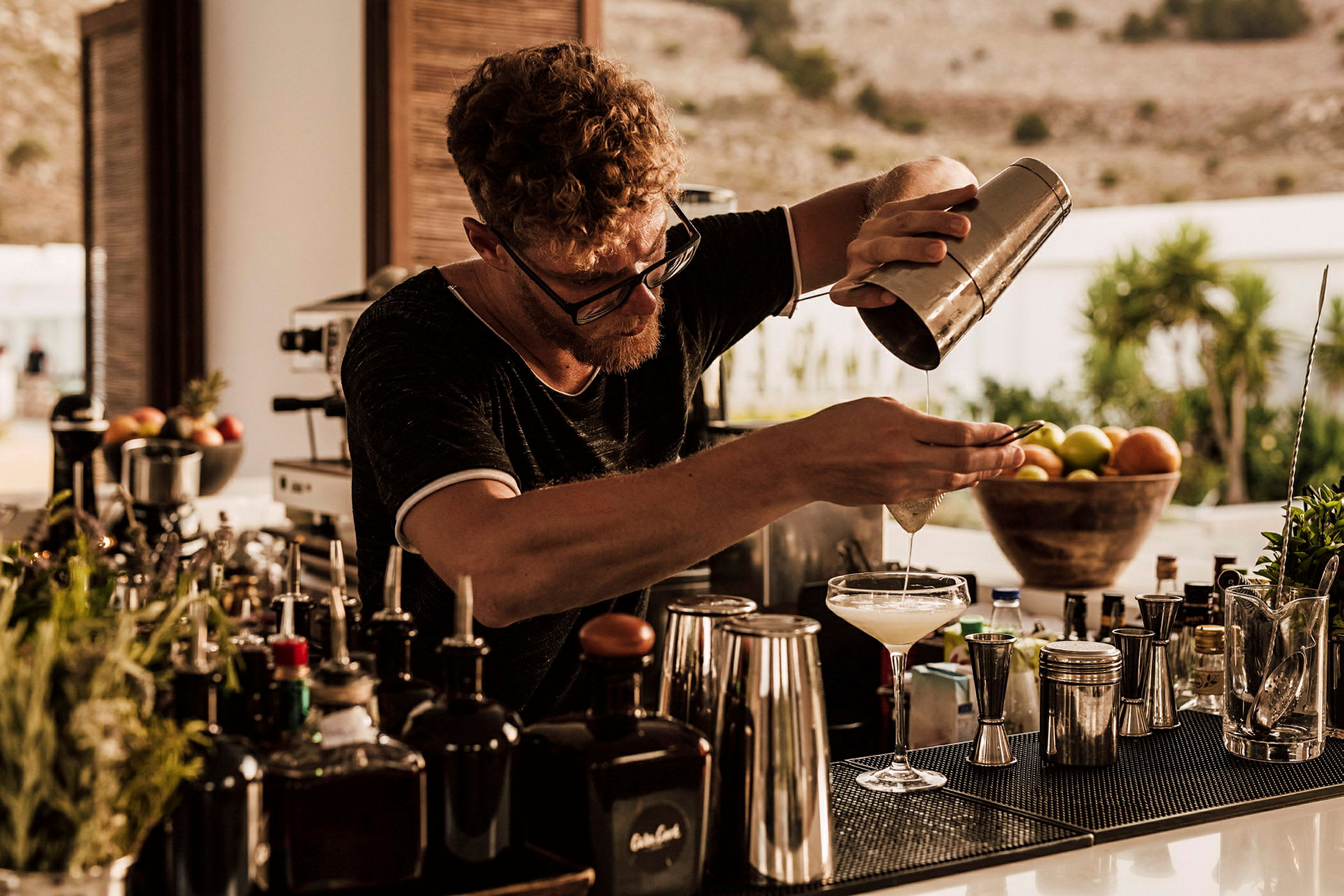 Person som blandar en drink bakom bardisken. (AI-genererad text)