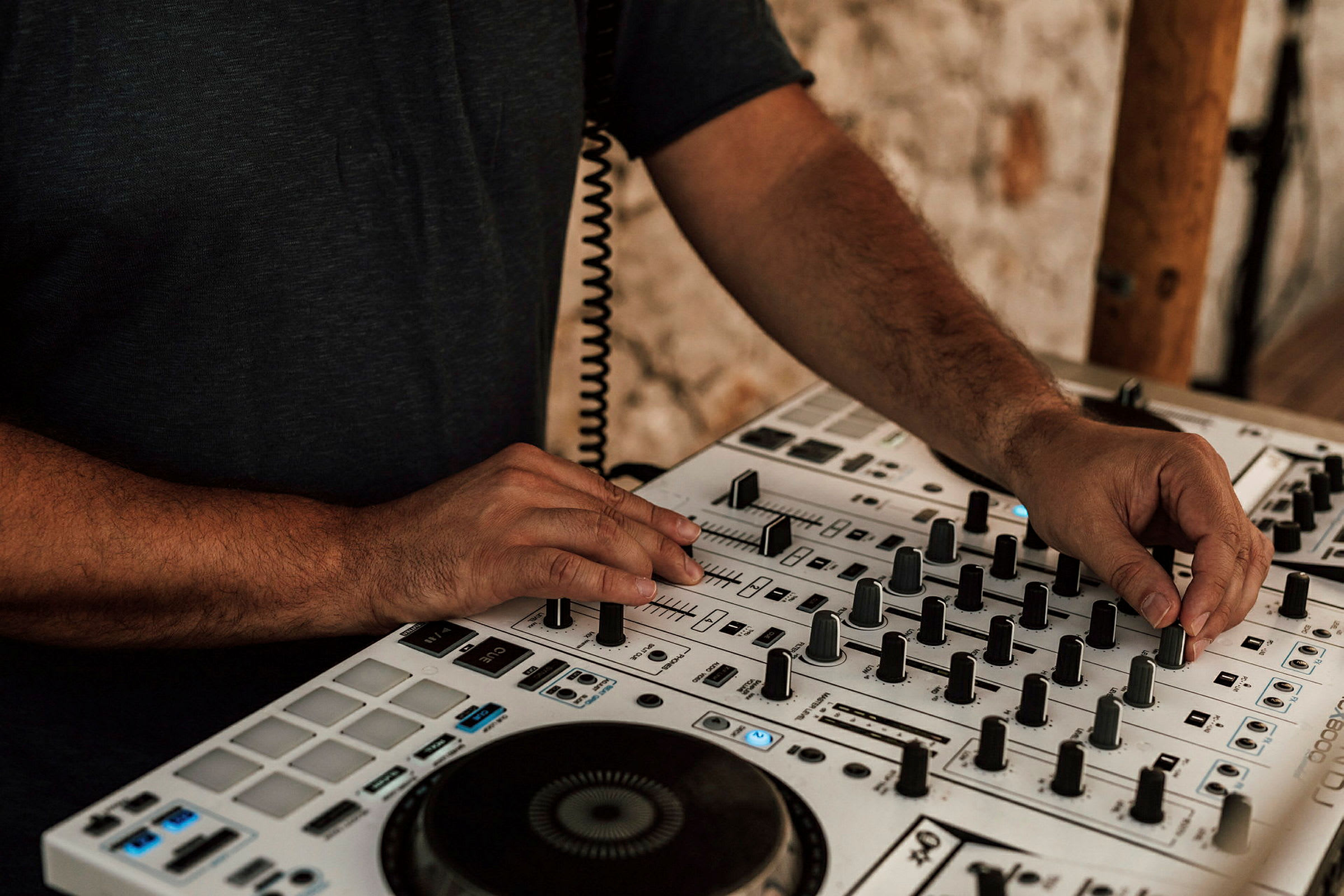 En person justerar kontroller på en DJ-mixer. (AI-genererad text)