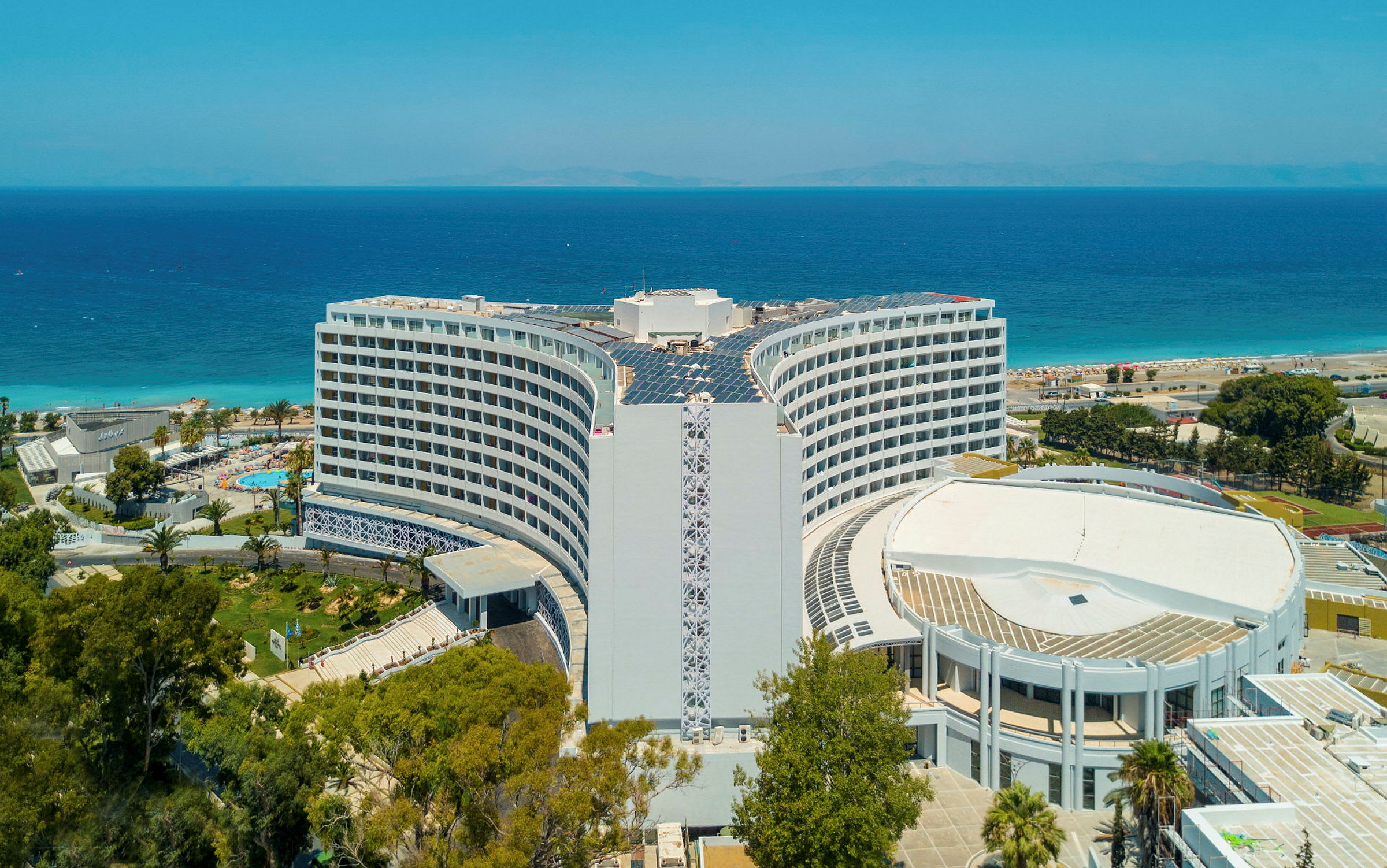 Hotellet med havet och stranden i bakgrunden. (AI-genererad text)