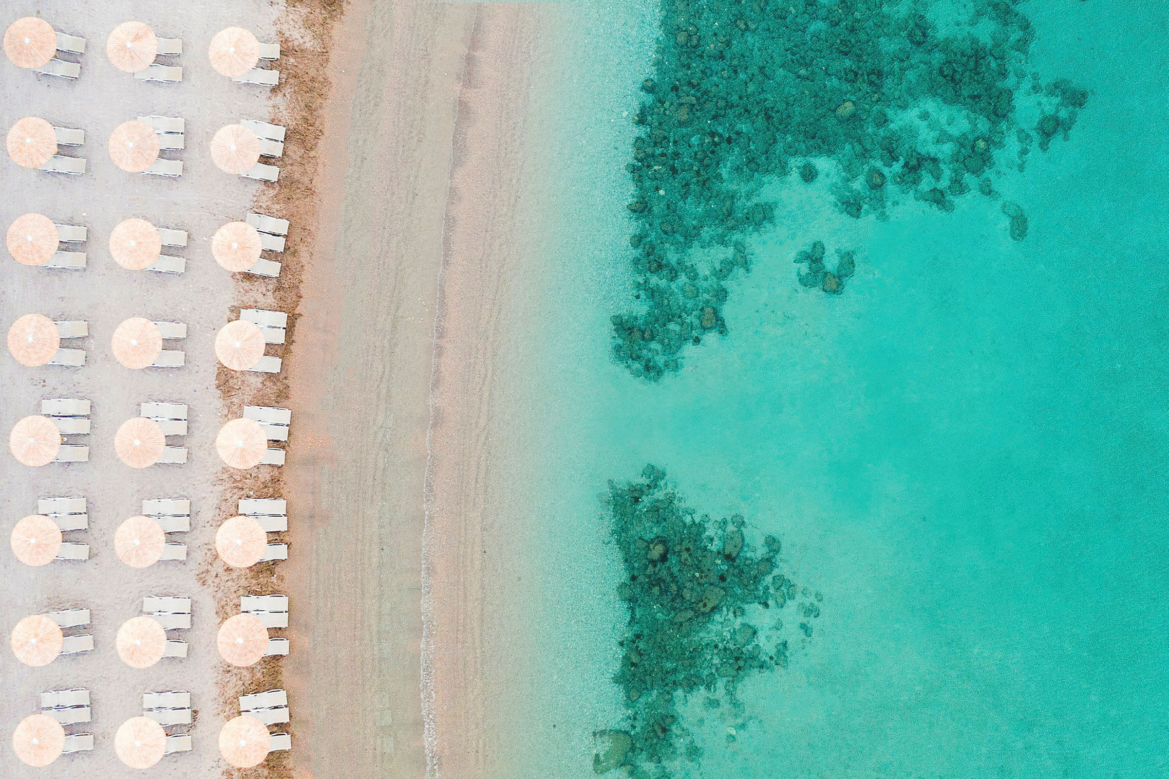 Strand med parasoller och solstolar på en rad vid kanten av turkost vatten. (AI-genererad text)